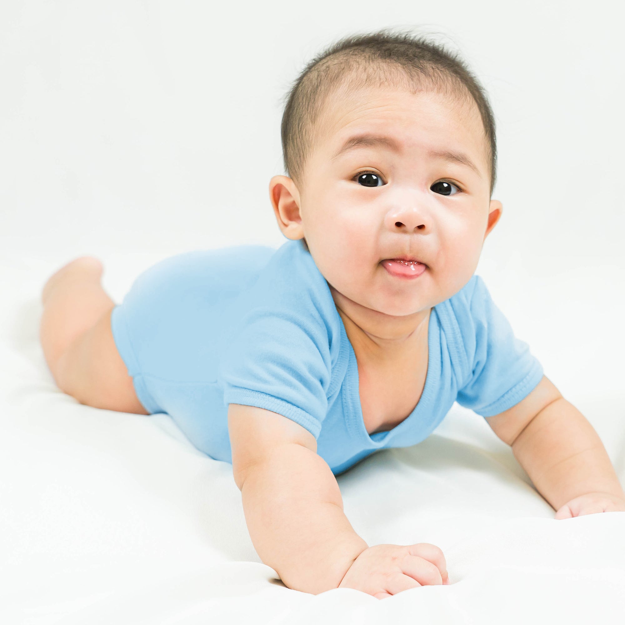 Baby in a light blue onesie on a white background