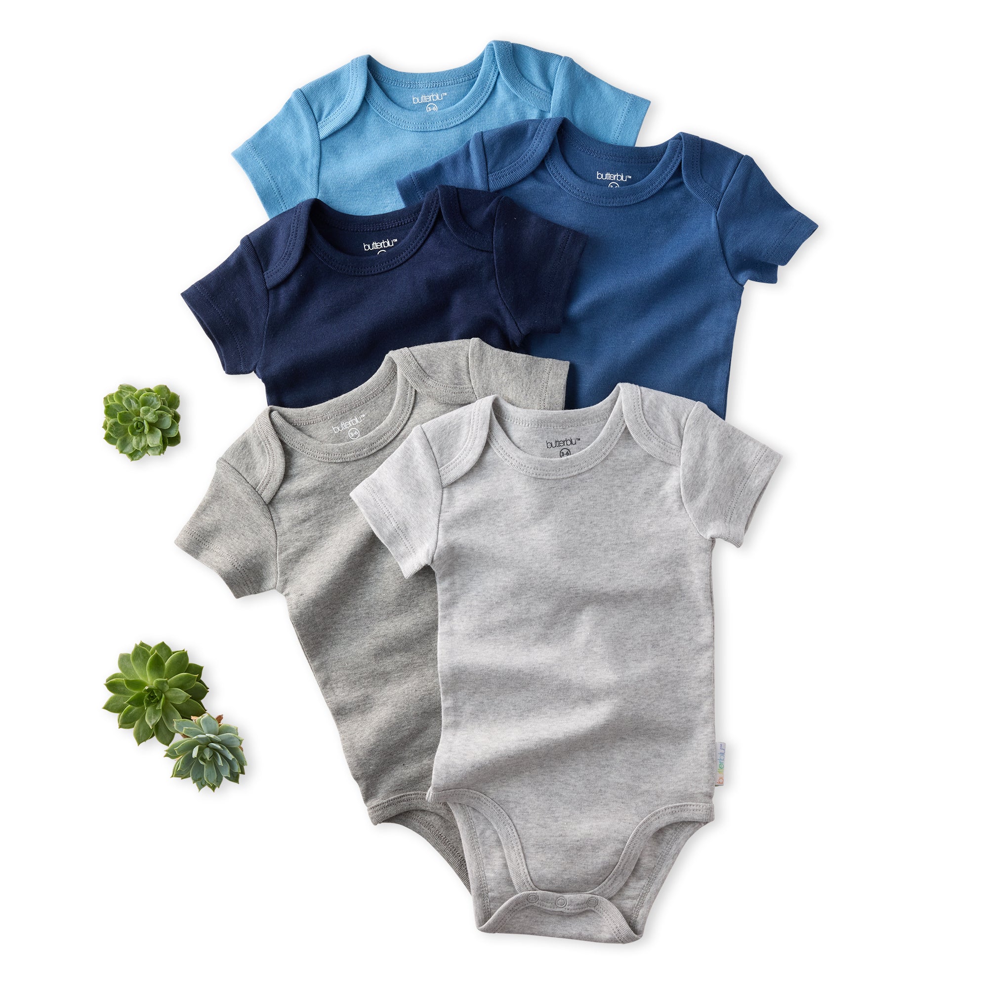 Set of baby bodysuits in blue, gray, and navy on a white background with small plants.