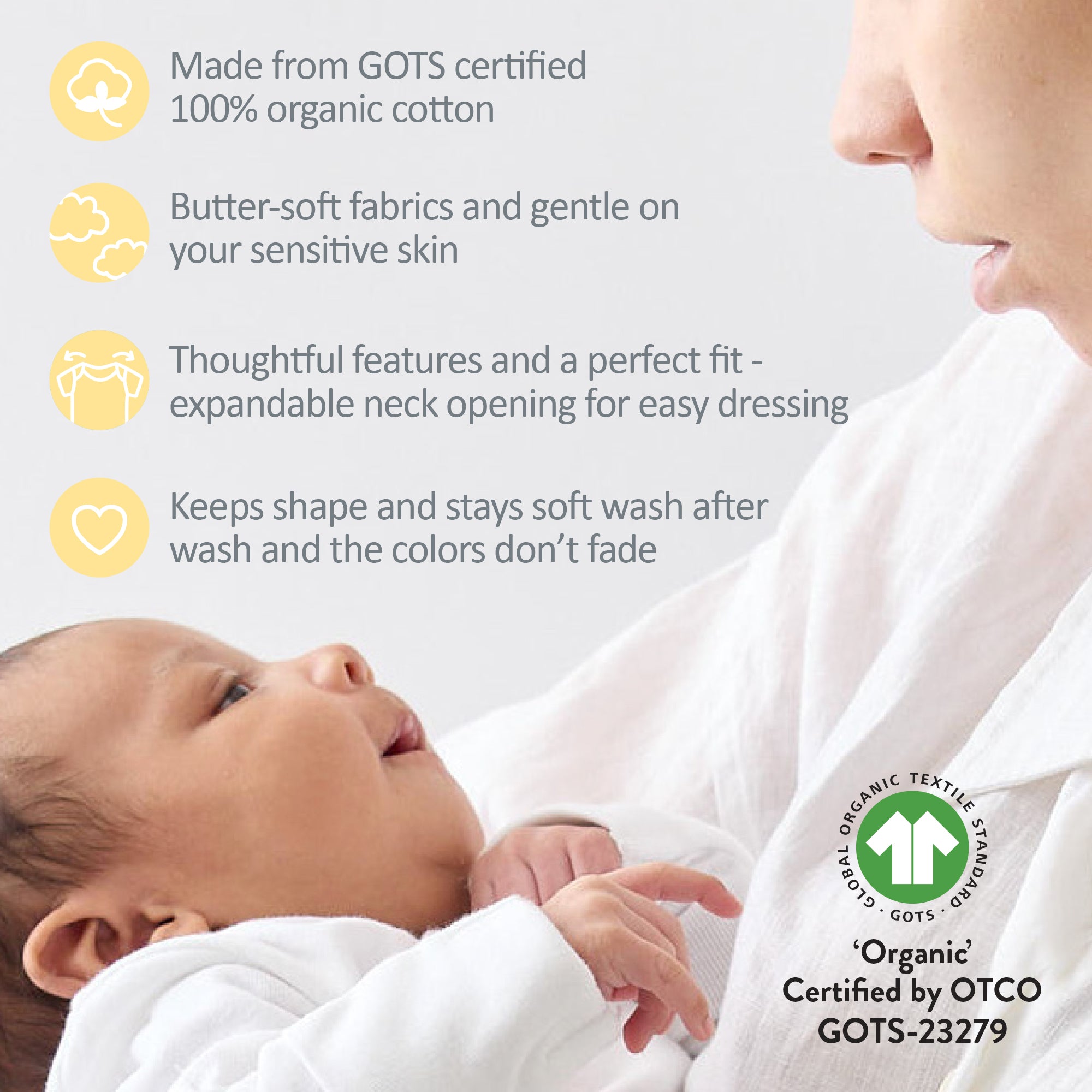 Baby wrapped in a white blanket with a woman, featuring GOTS certification text.