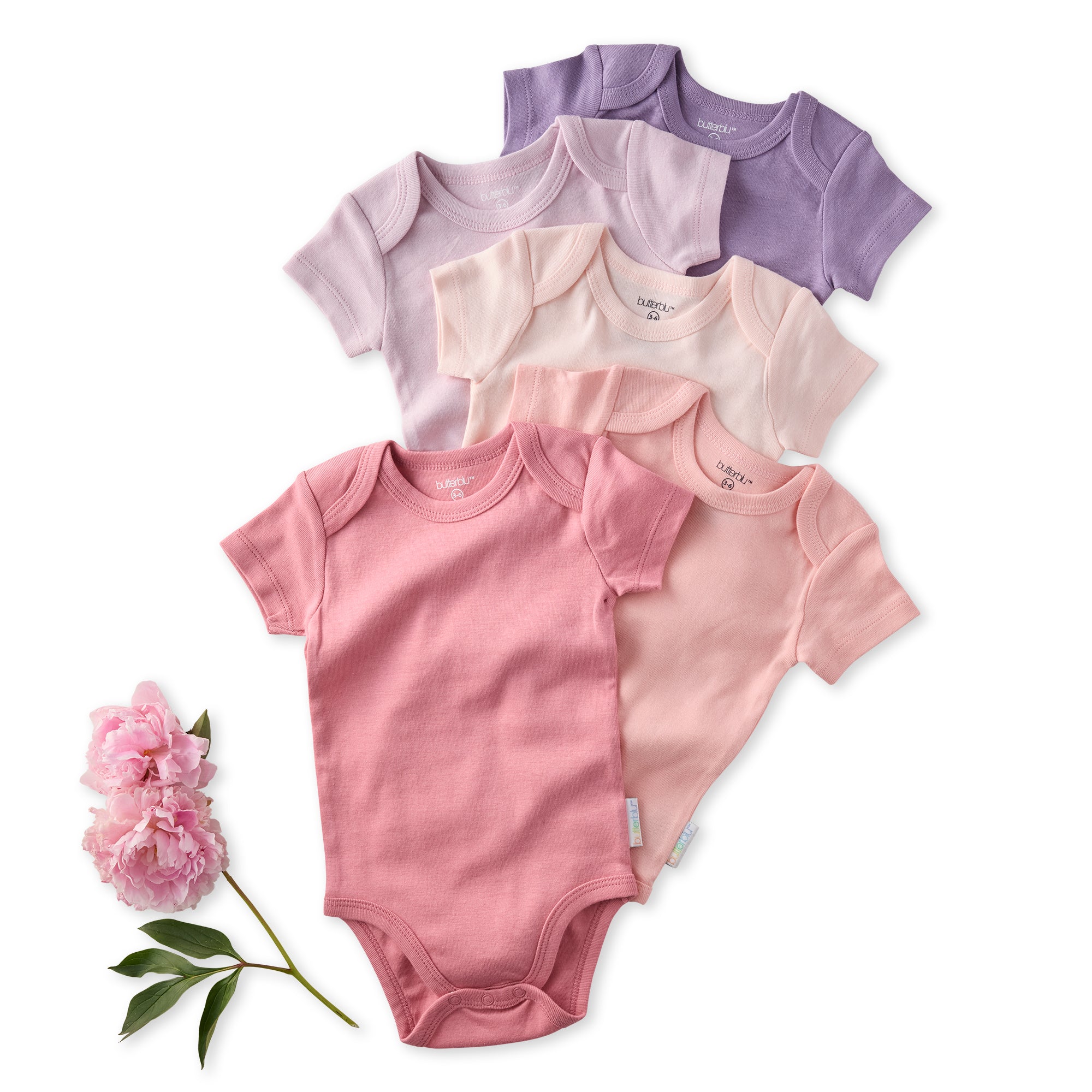 Set of baby bodysuits in pink and purple on a white background with a pink flower.