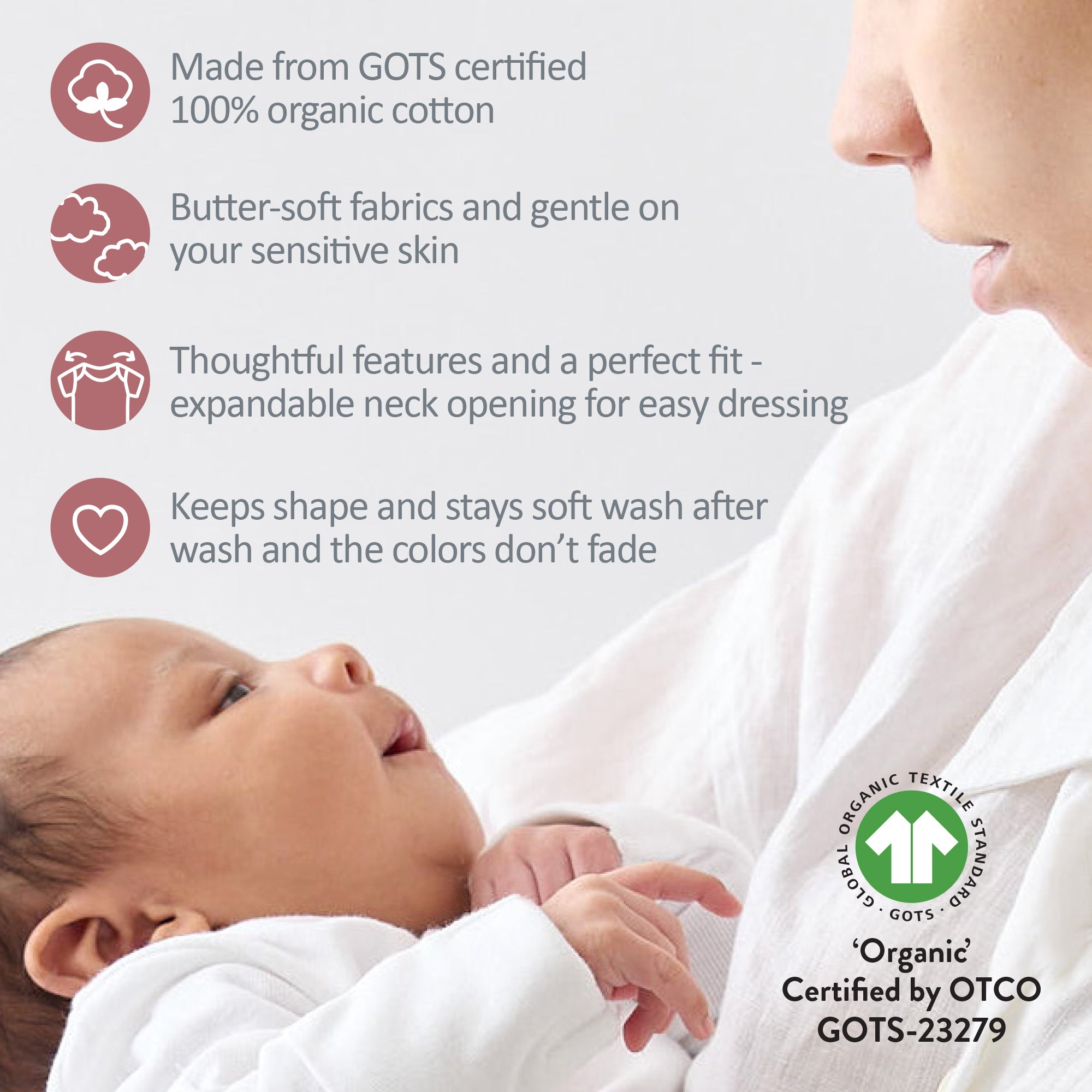 Baby wearing a white garment with text about organic cotton and GOTS certification, next to a person.