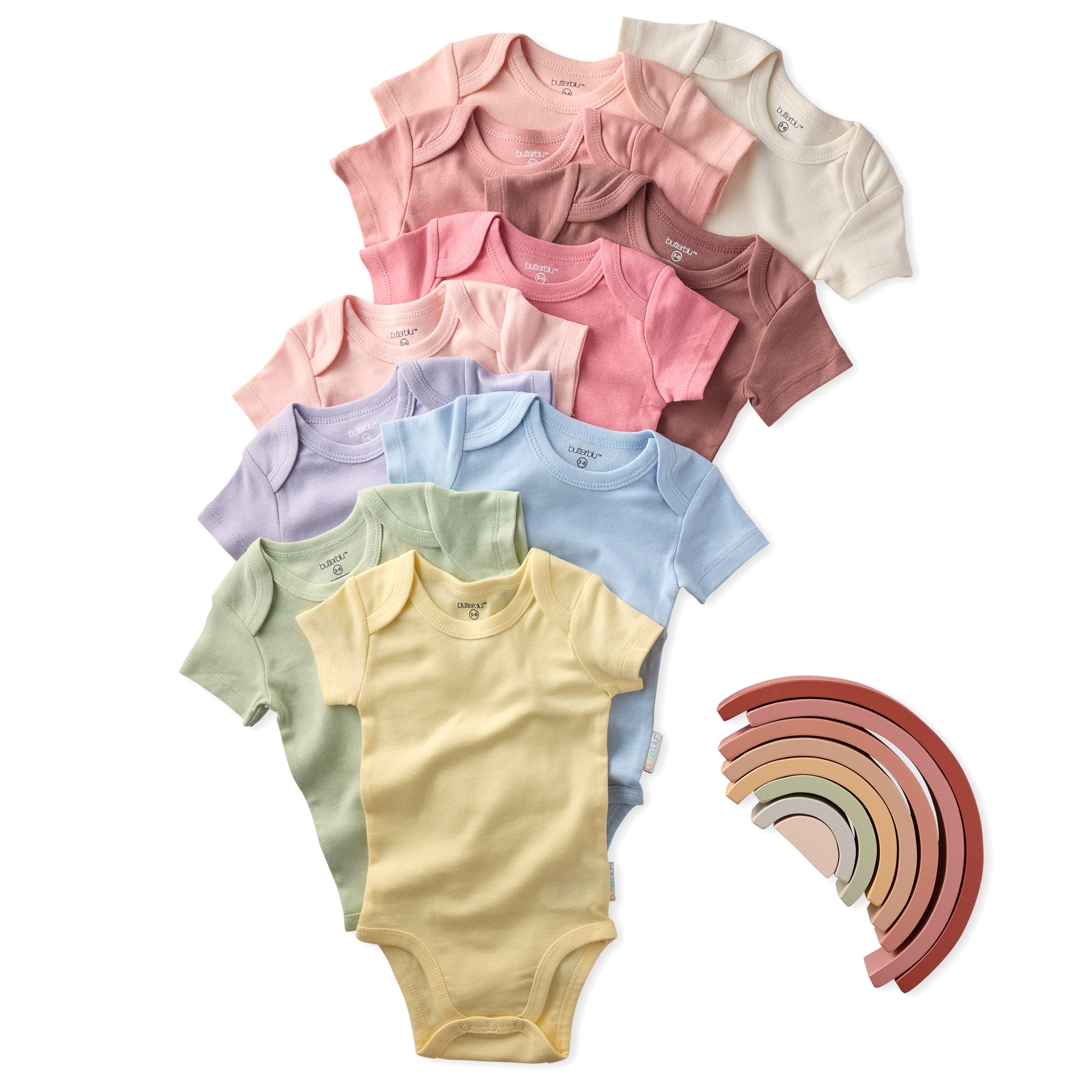 Set of colorful baby bodysuits with a rainbow-shaped wooden toy on a white background