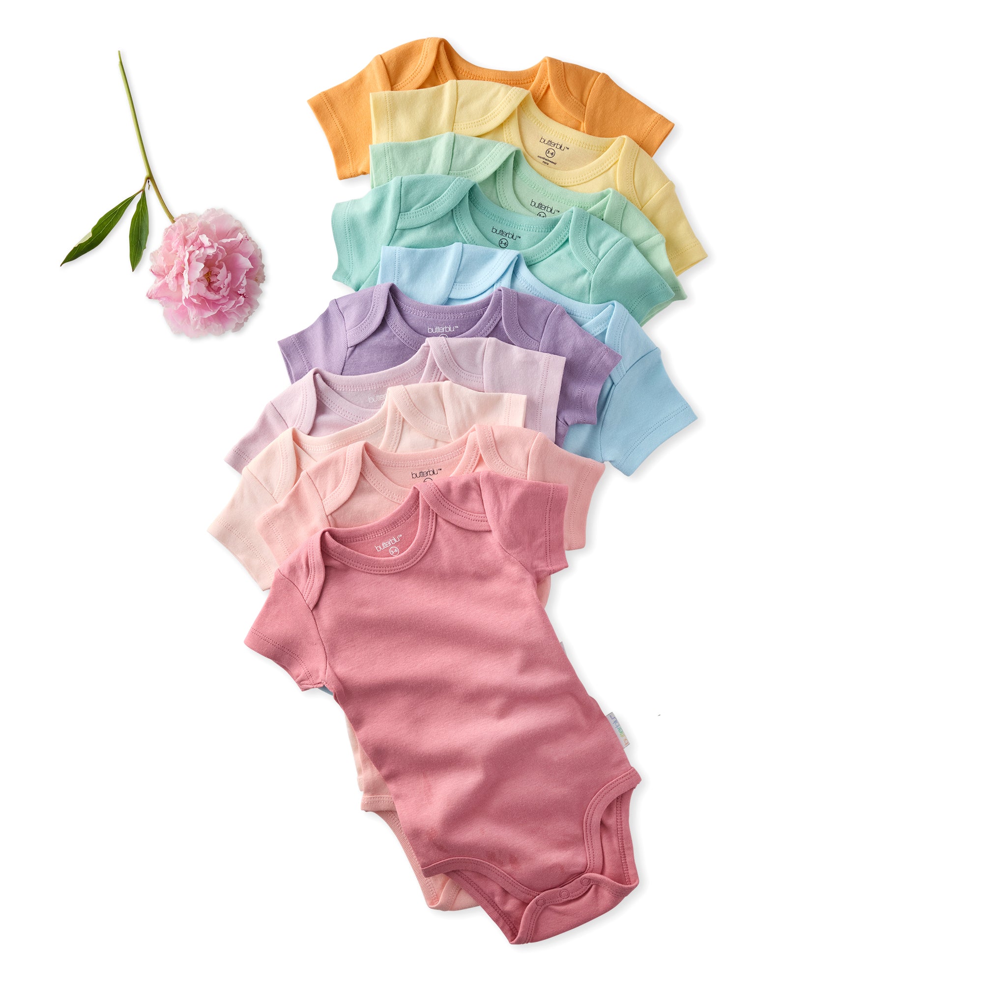 Set of colorful baby bodysuits arranged in a fan-like pattern on a white background with a pink flower and green leaf.