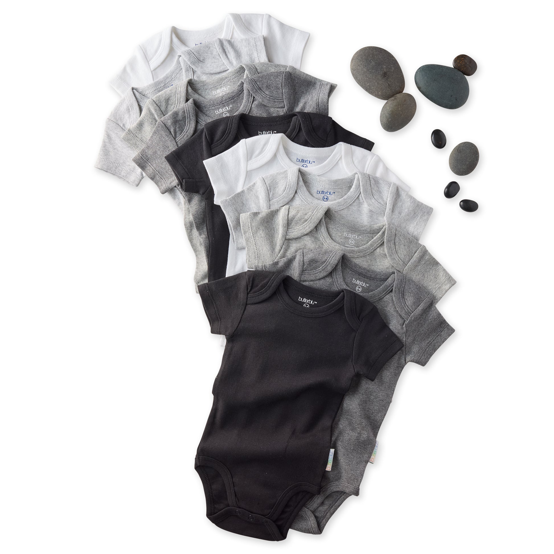 Stack of black and gray baby onesies with rocks on a white background