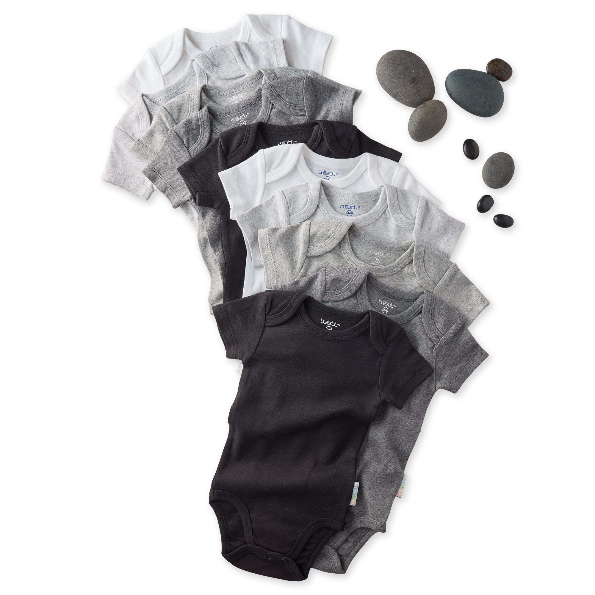 Stack of black and gray baby onesies with rocks on a white background
