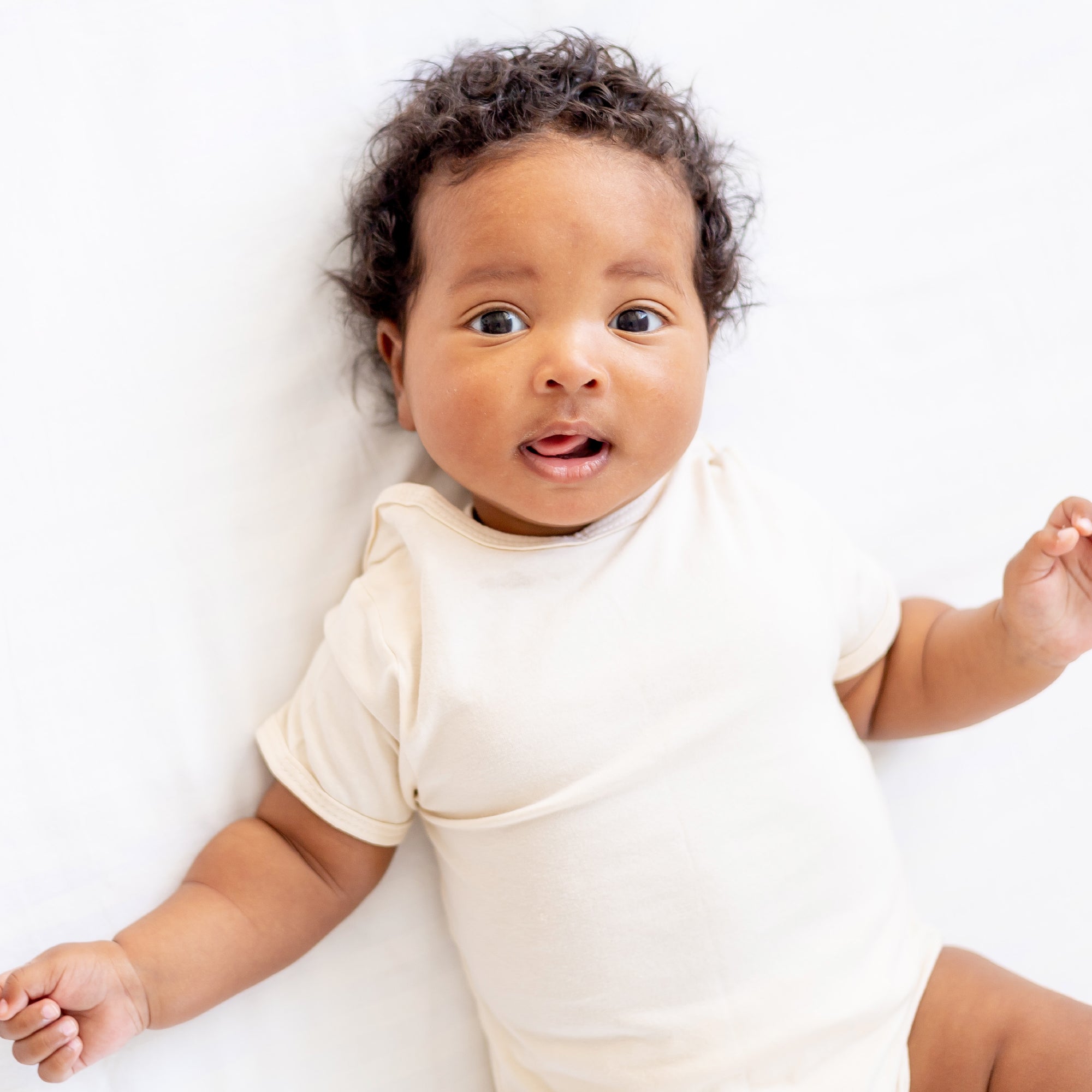 Baby in a white onesie on a white background