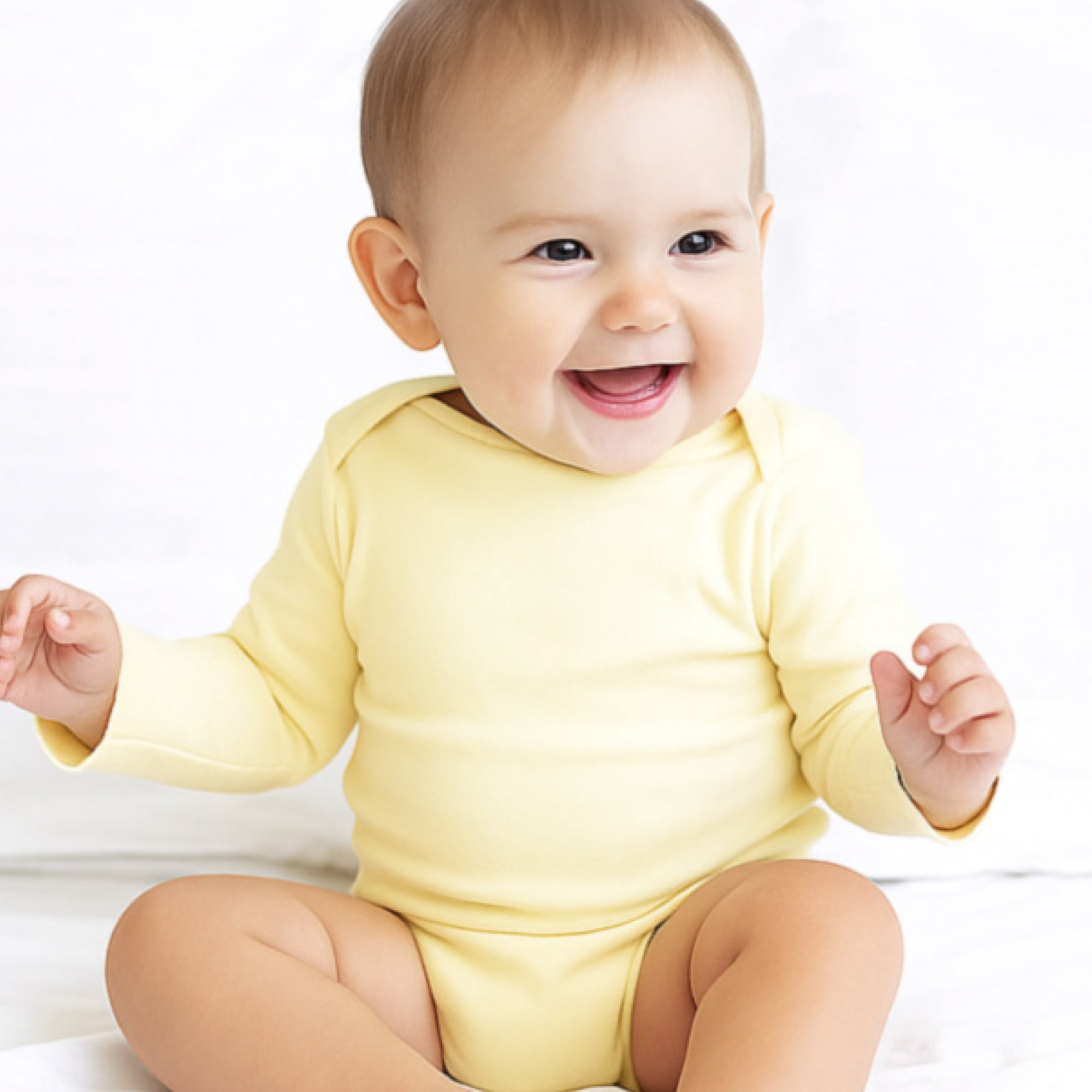 Baby wearing a yellow onesie on a white background