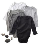 Set of baby bodysuits in black, gray, and white on a white background with rocks.