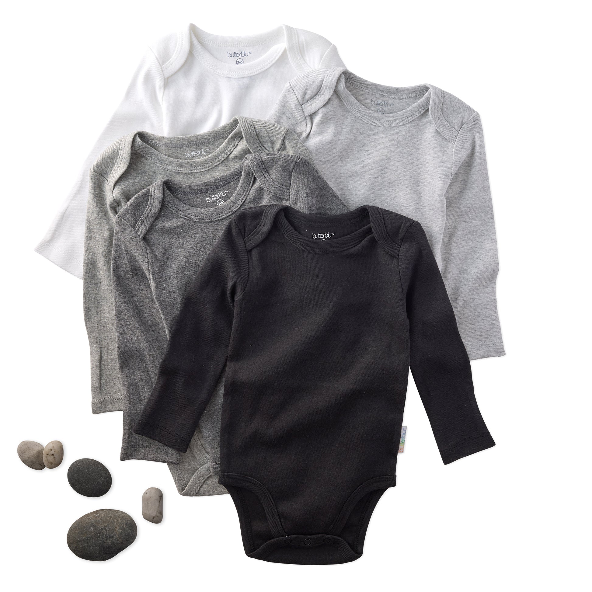 Set of baby bodysuits in black, gray, and white on a white background with rocks.