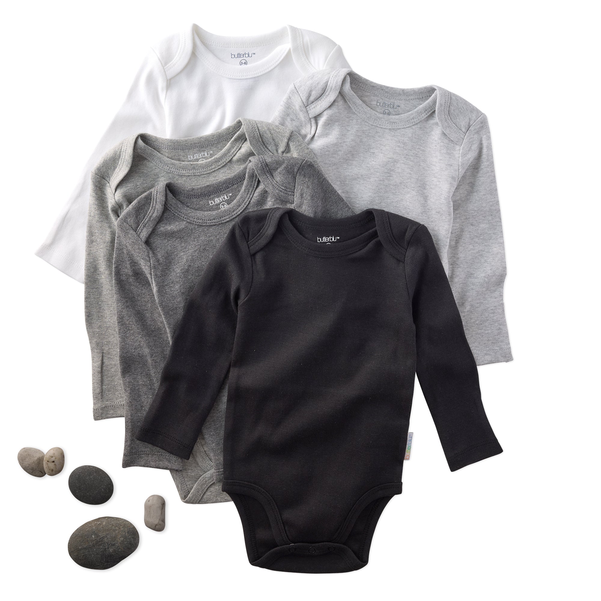 Set of baby bodysuits in black, gray, and white on a white background with rocks.