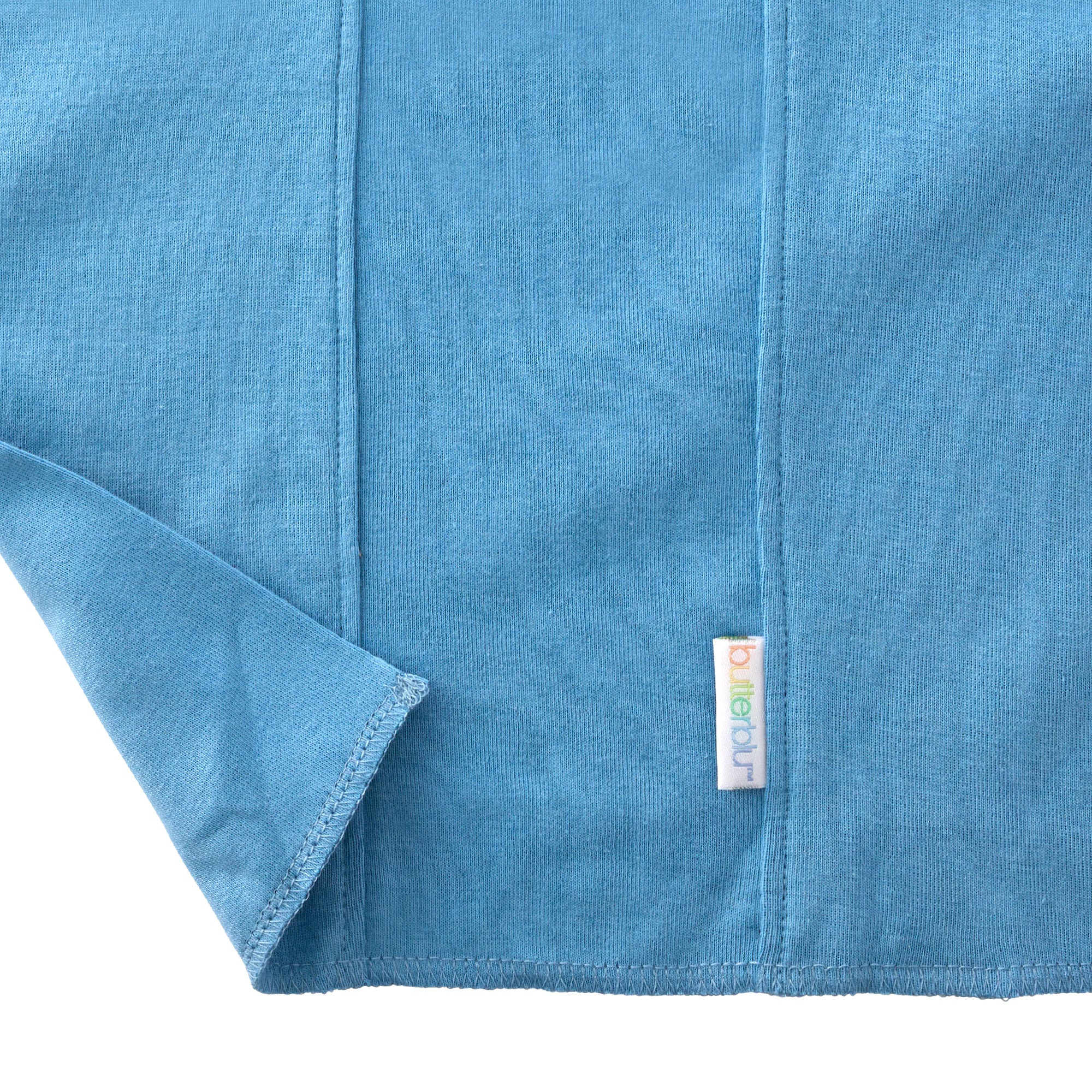 Close-up of a blue fabric with a brand label on a white background