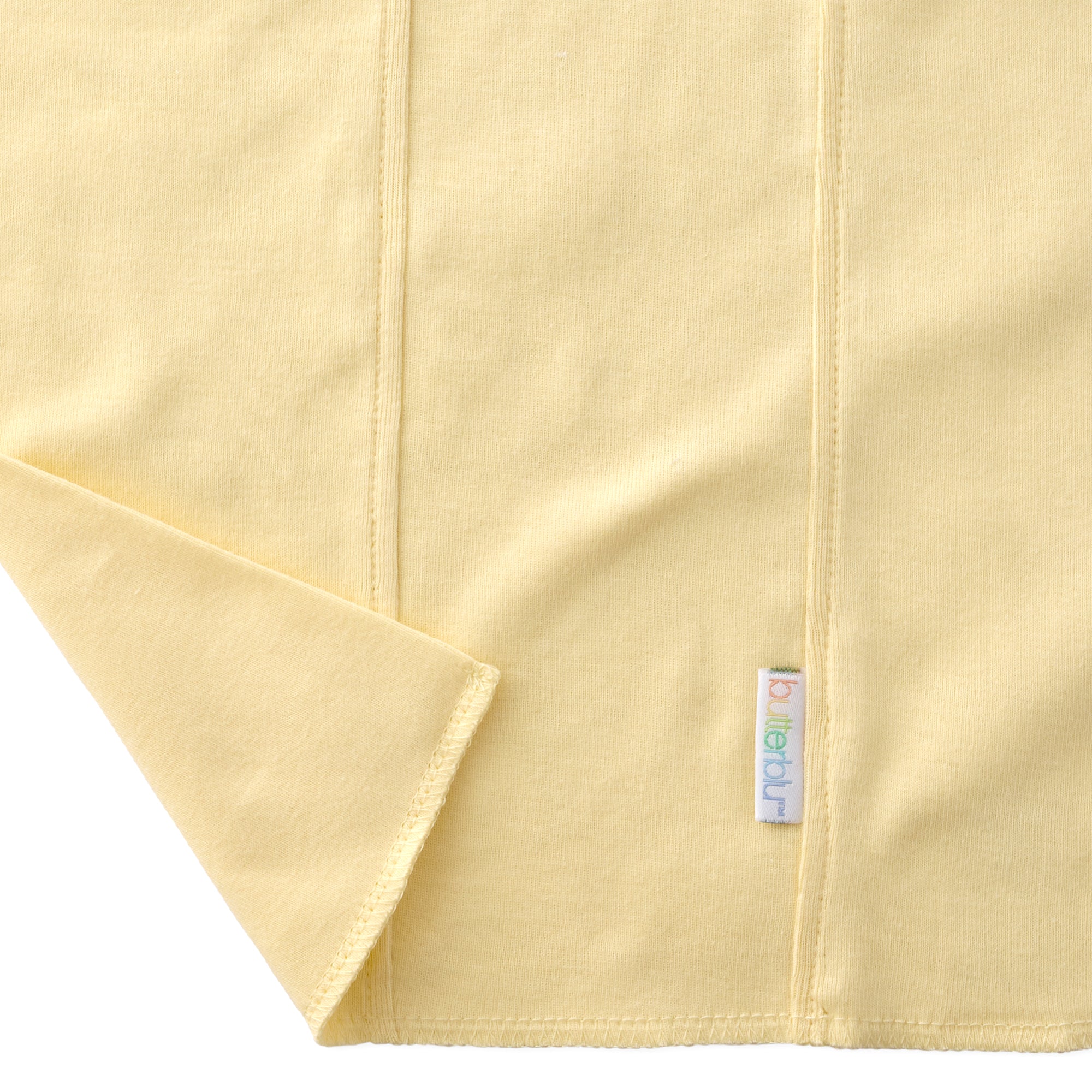 Close-up of a yellow fabric with a brand label on a white background