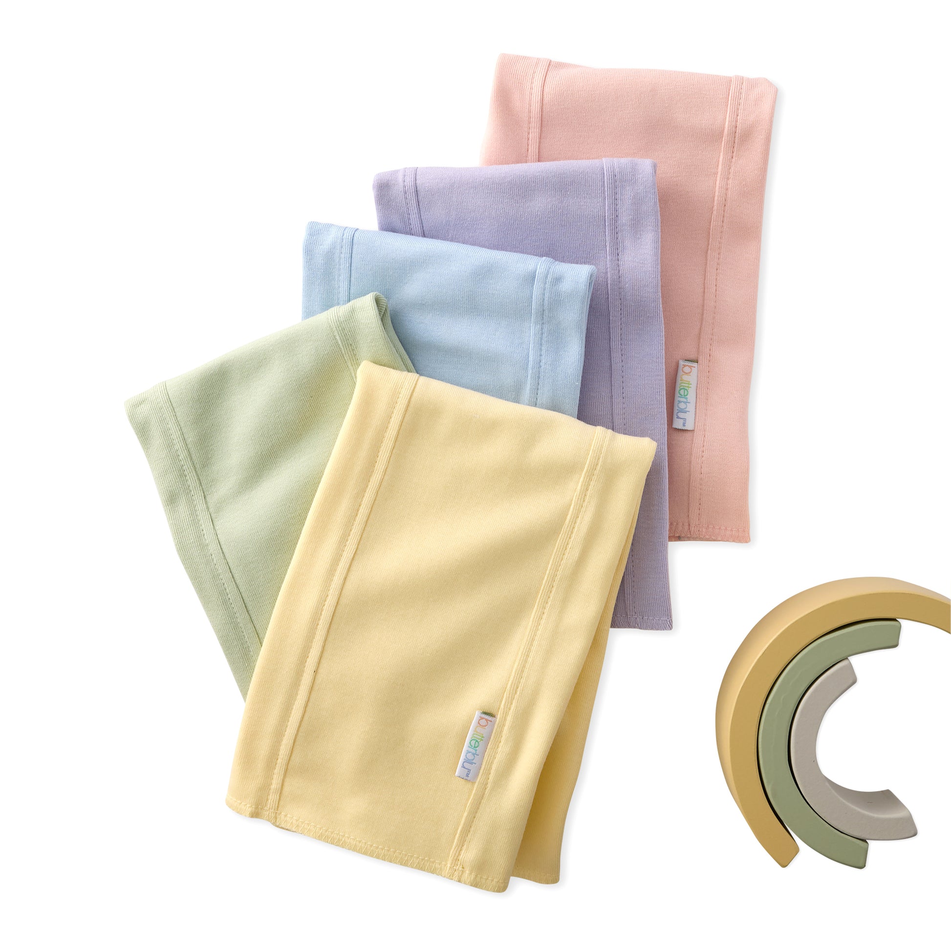 Set of folded fabric swatches in various colors with a wooden toy on a white background