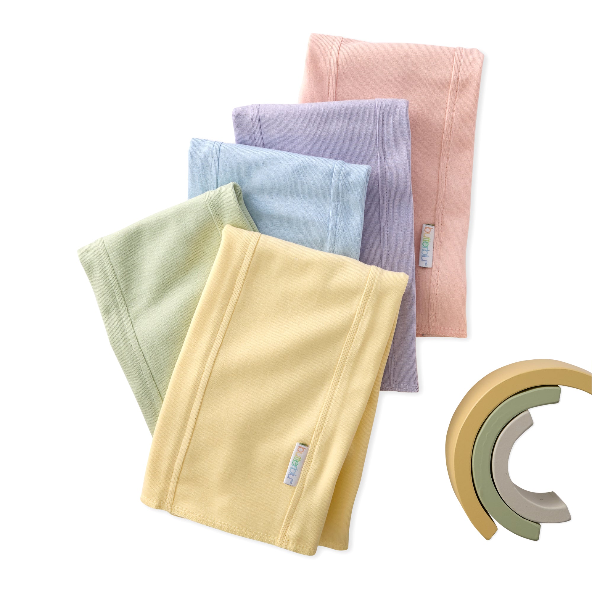 Set of folded fabric swatches in various colors with a wooden toy on a white background