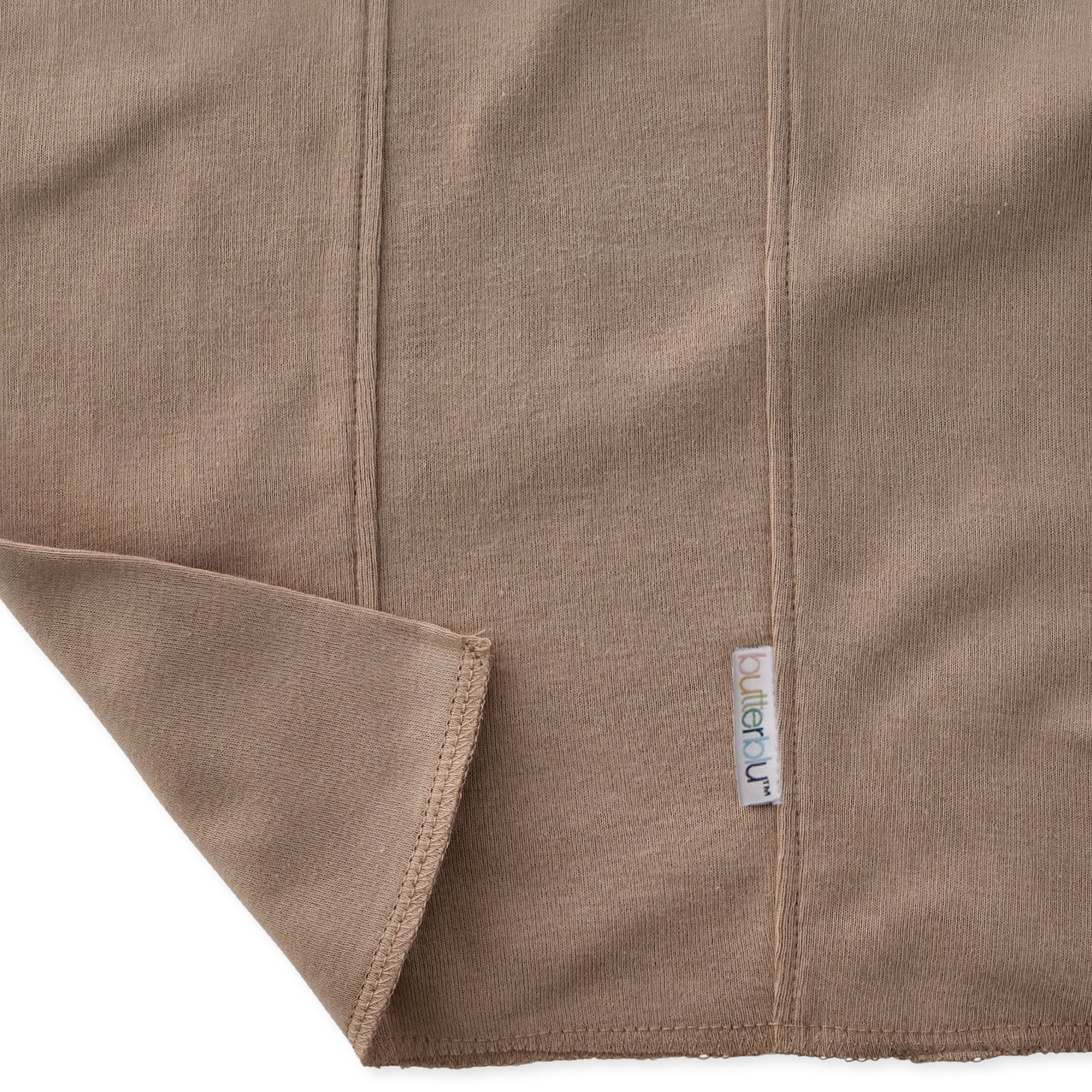 Close-up of a brown fabric with a visible brand label on a white background