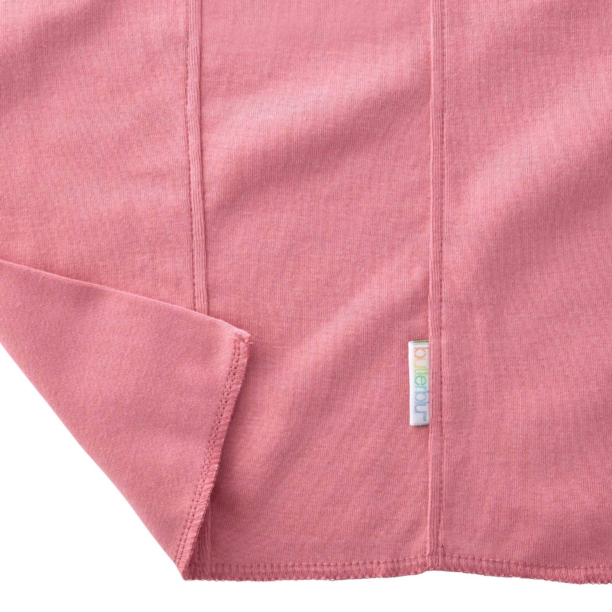 Close-up of a pink fabric with a brand label on a white background