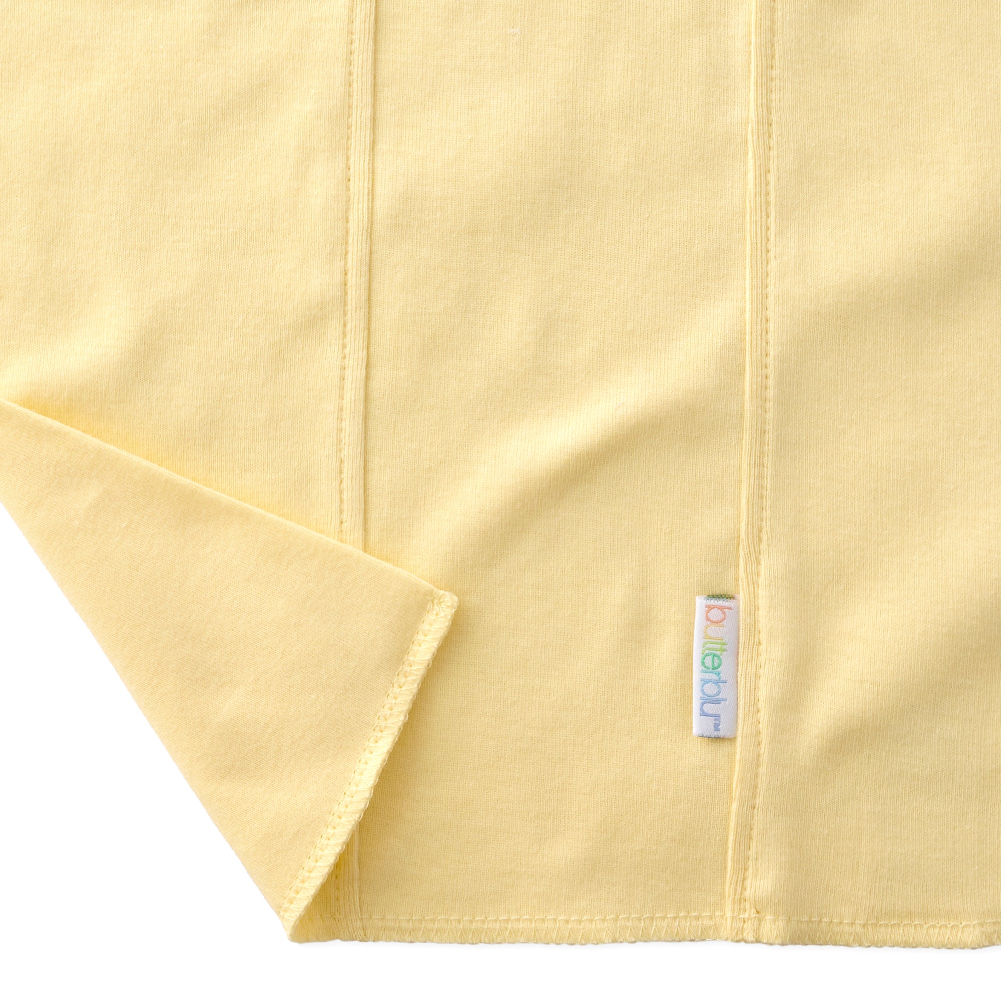 Close-up of a yellow fabric with a brand label on a white background
