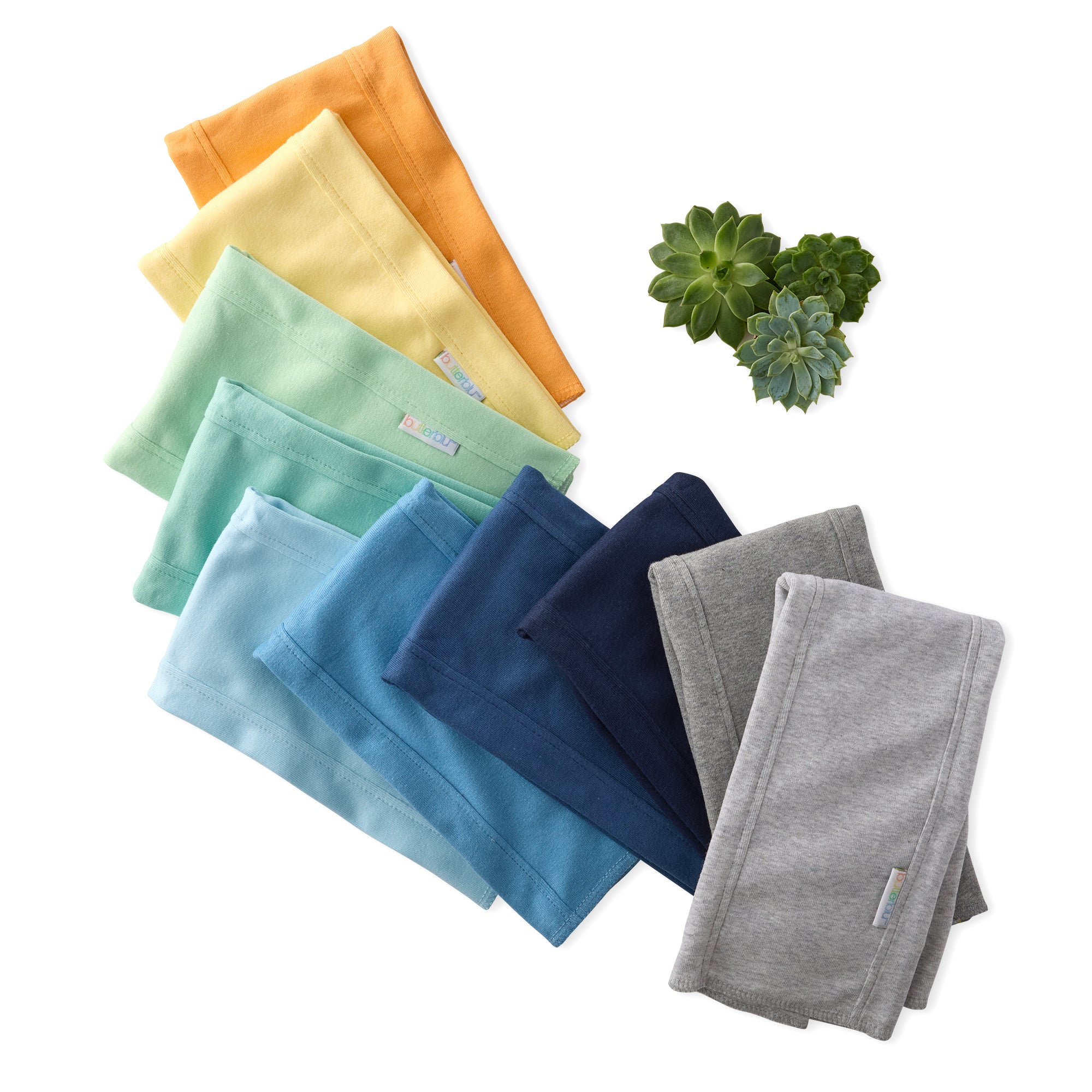 Set of folded colorful towels on a white background with succulents.