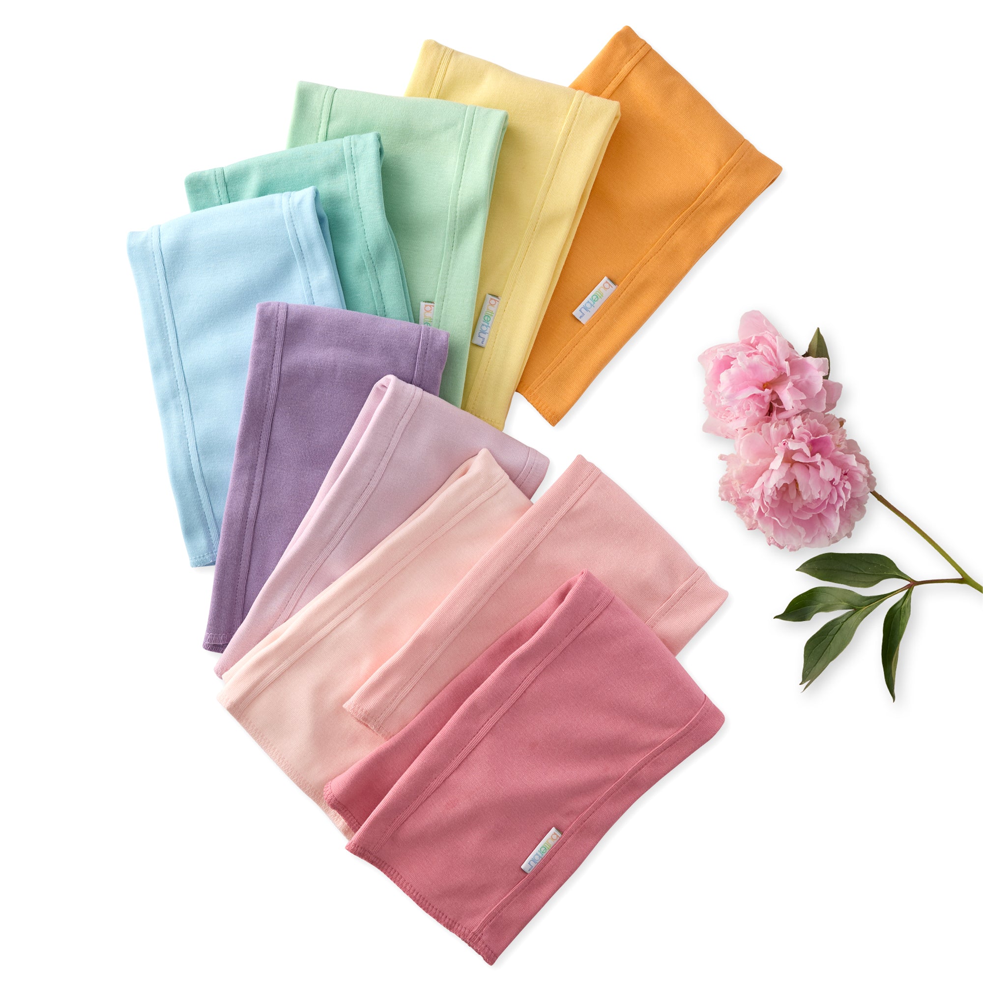 Set of colorful folded towels with a pink flower on a white background