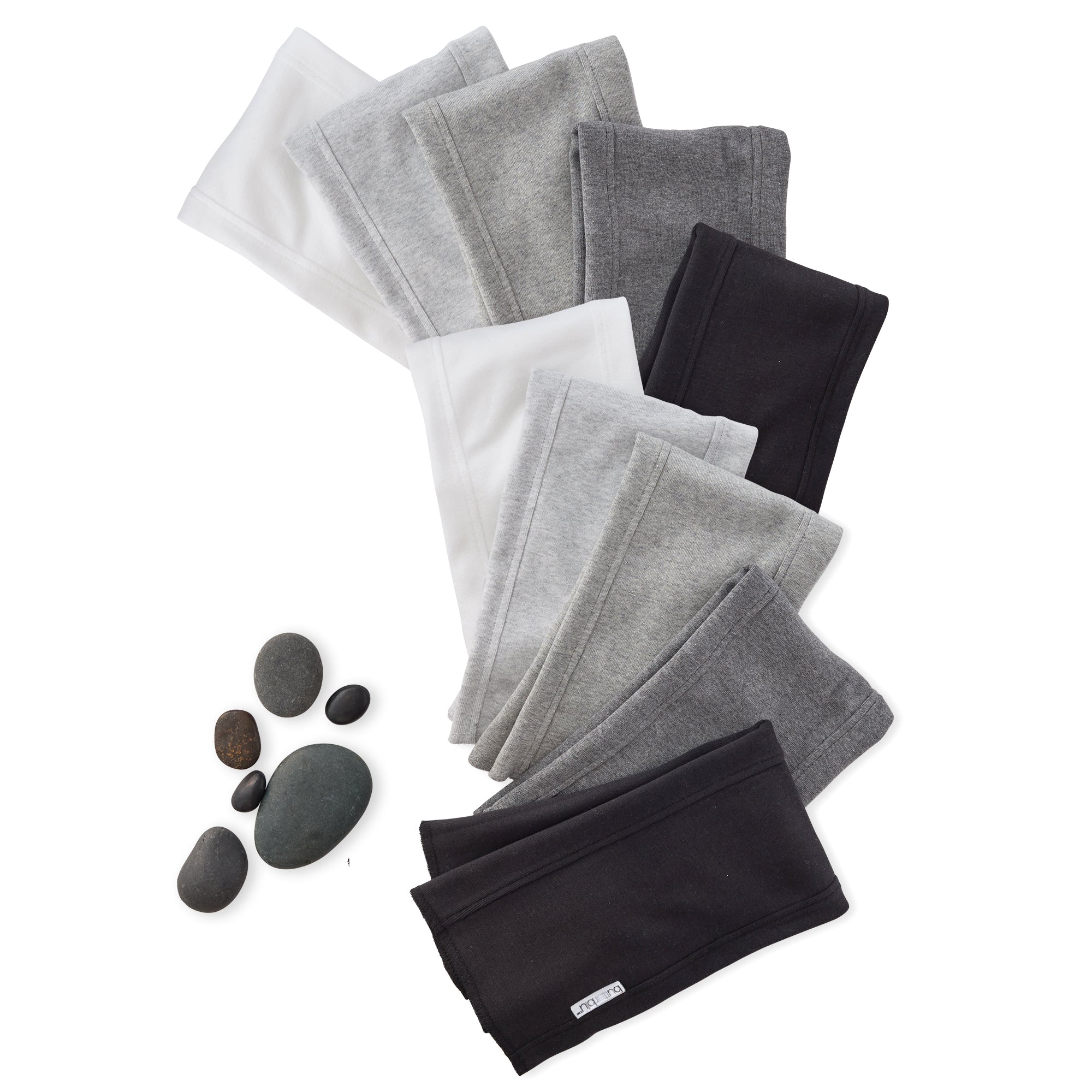Set of black and gray folded cloths with stones on a white background