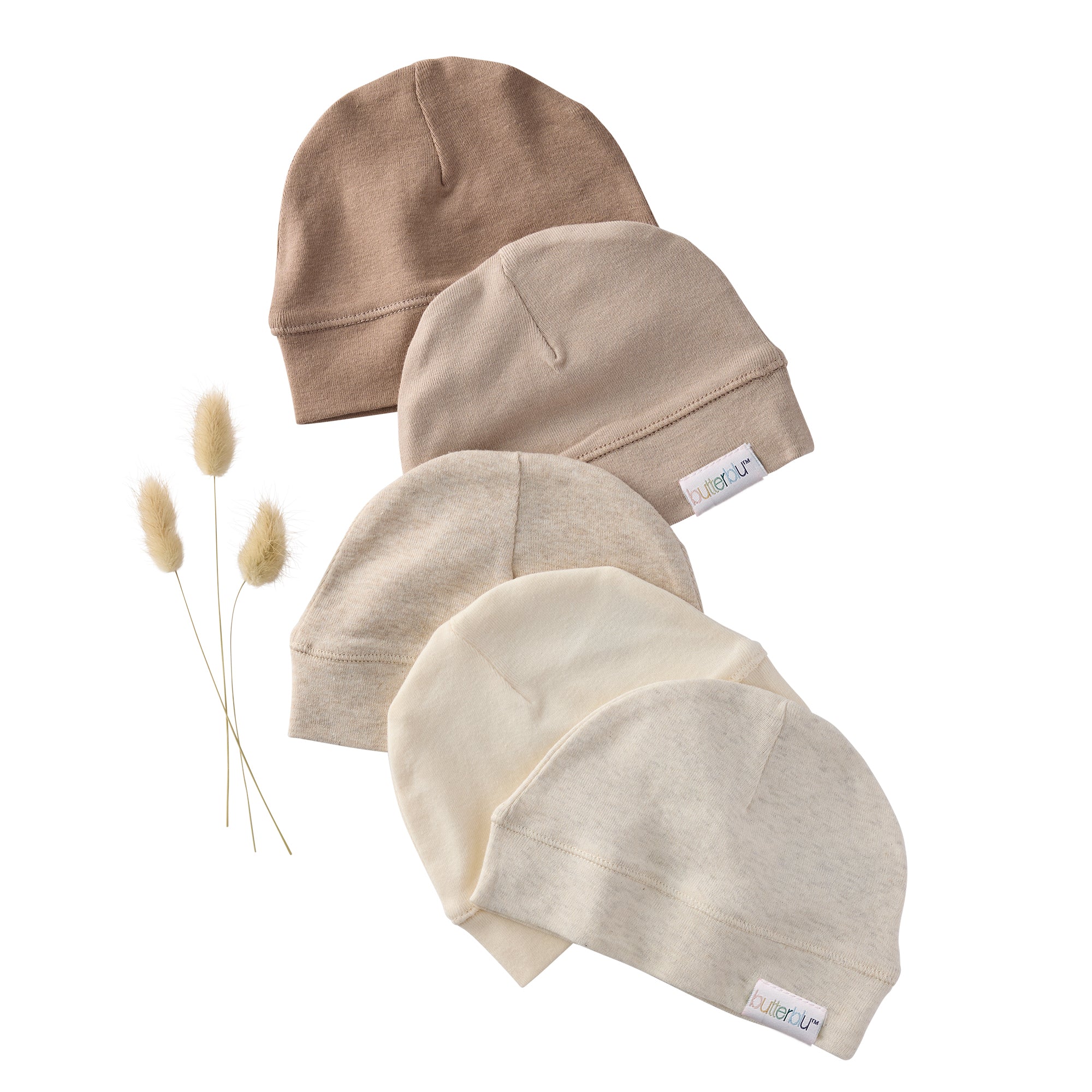 Five beige baby hats with labels on a white background
