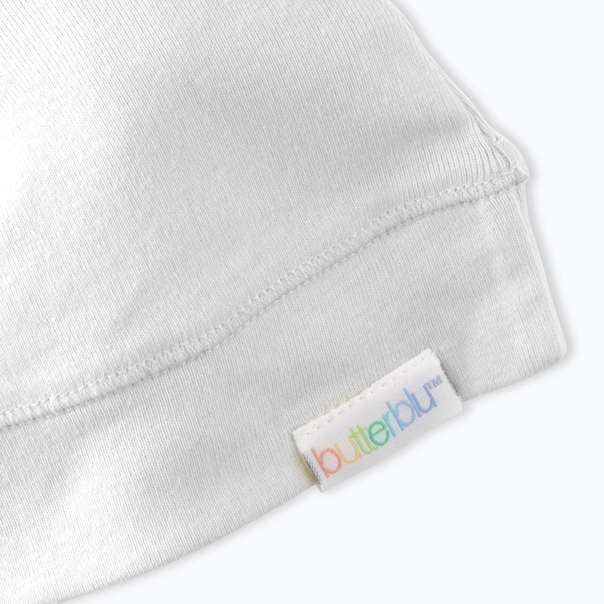 Close-up of a white fabric with a 'butterblu' label on a white background
