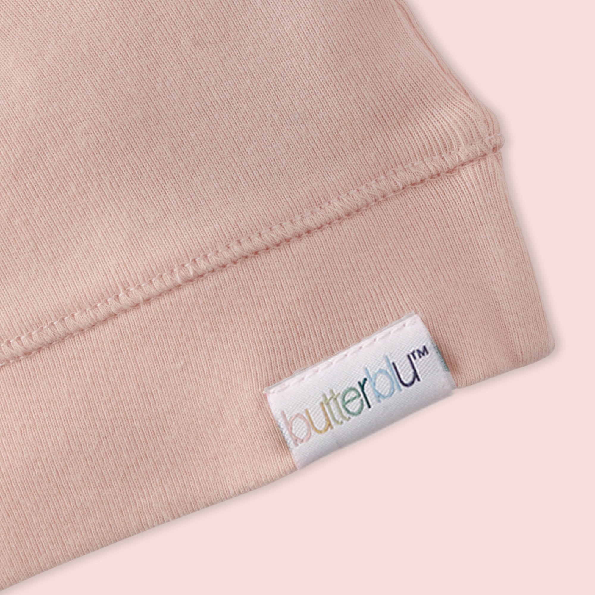 Close-up of a pink garment with a 'butterfly' brand label.