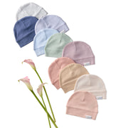 Set of pastel-colored baby hats arranged in a circular pattern with flowers on a white background.