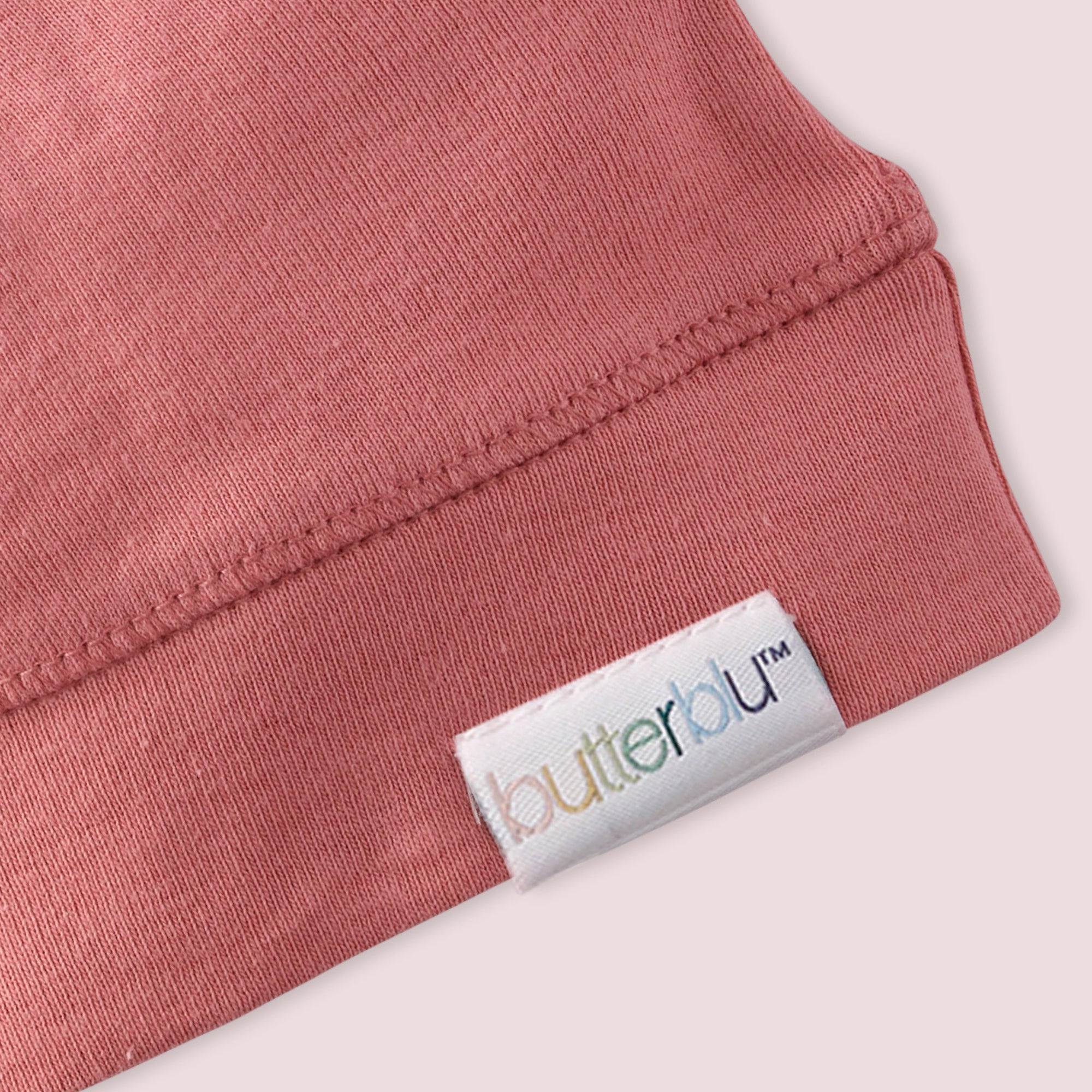 Close-up of a pink garment with a 'butterbu' label on a light background