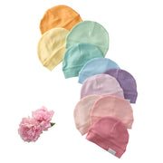 Set of colorful baby hats arranged in a circle with a pink flower on a white background