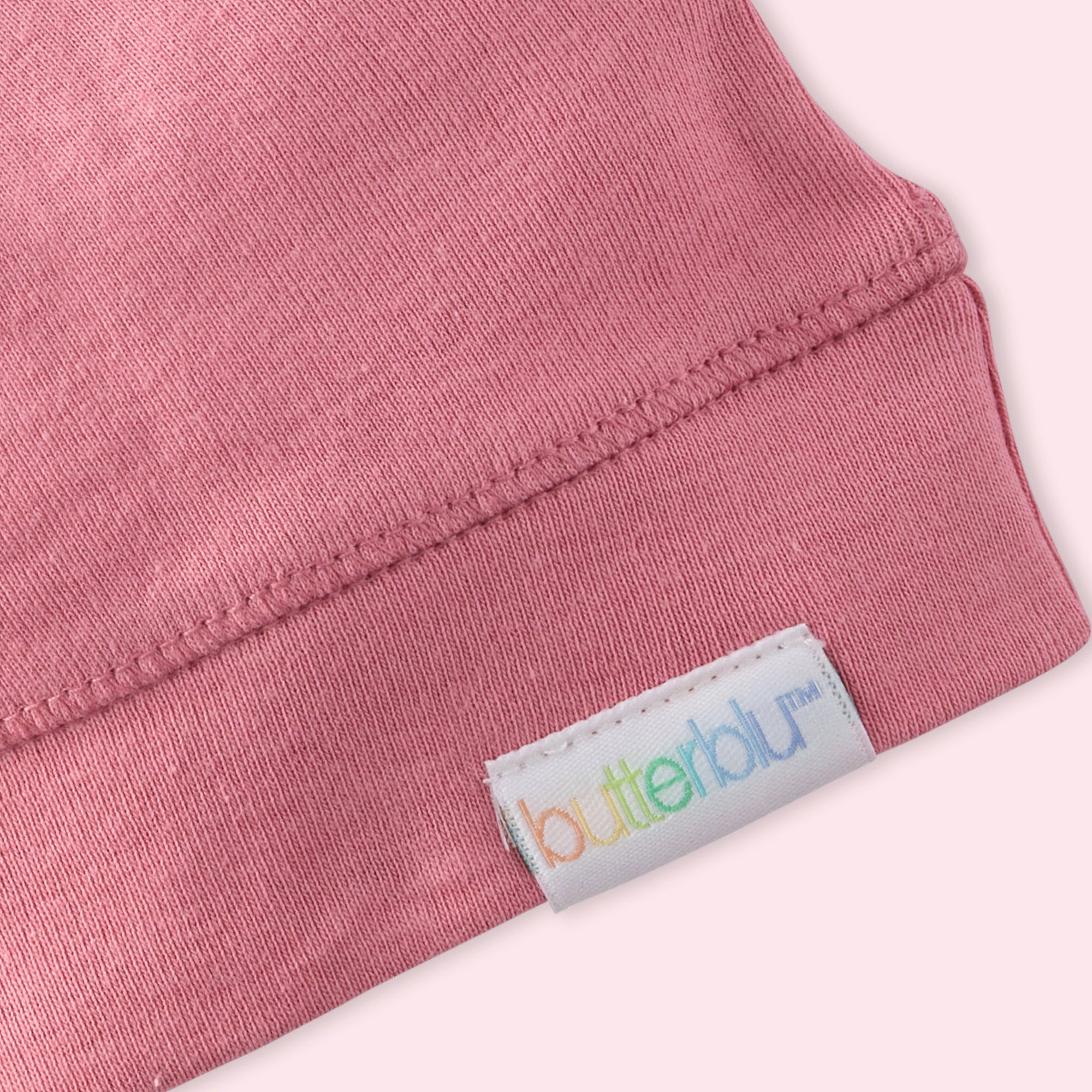 Close-up of a pink fabric with a 'butterbu' label on a white background