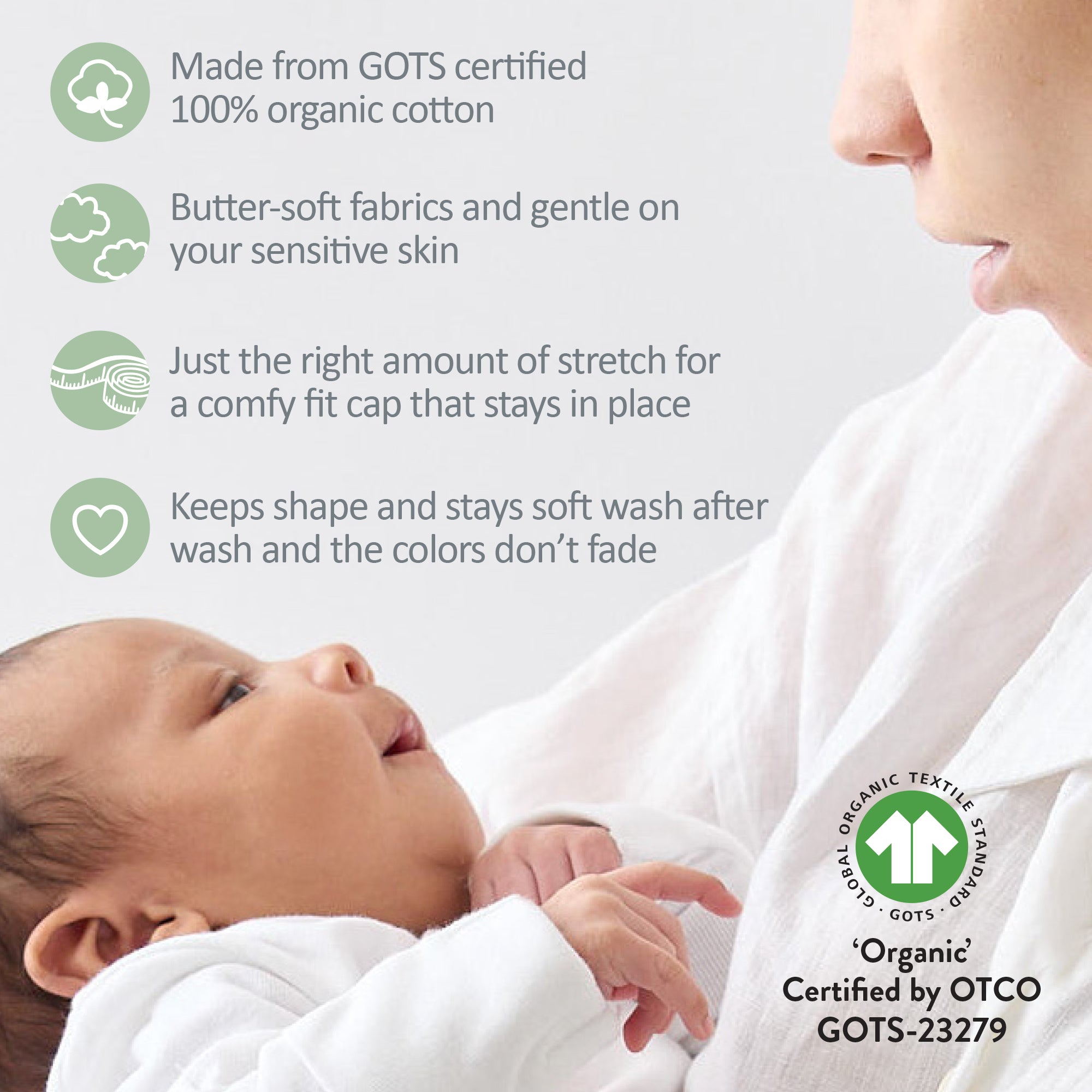 Baby wearing a white organic cotton cap with a mother holding the baby, featuring GOTS certification details.