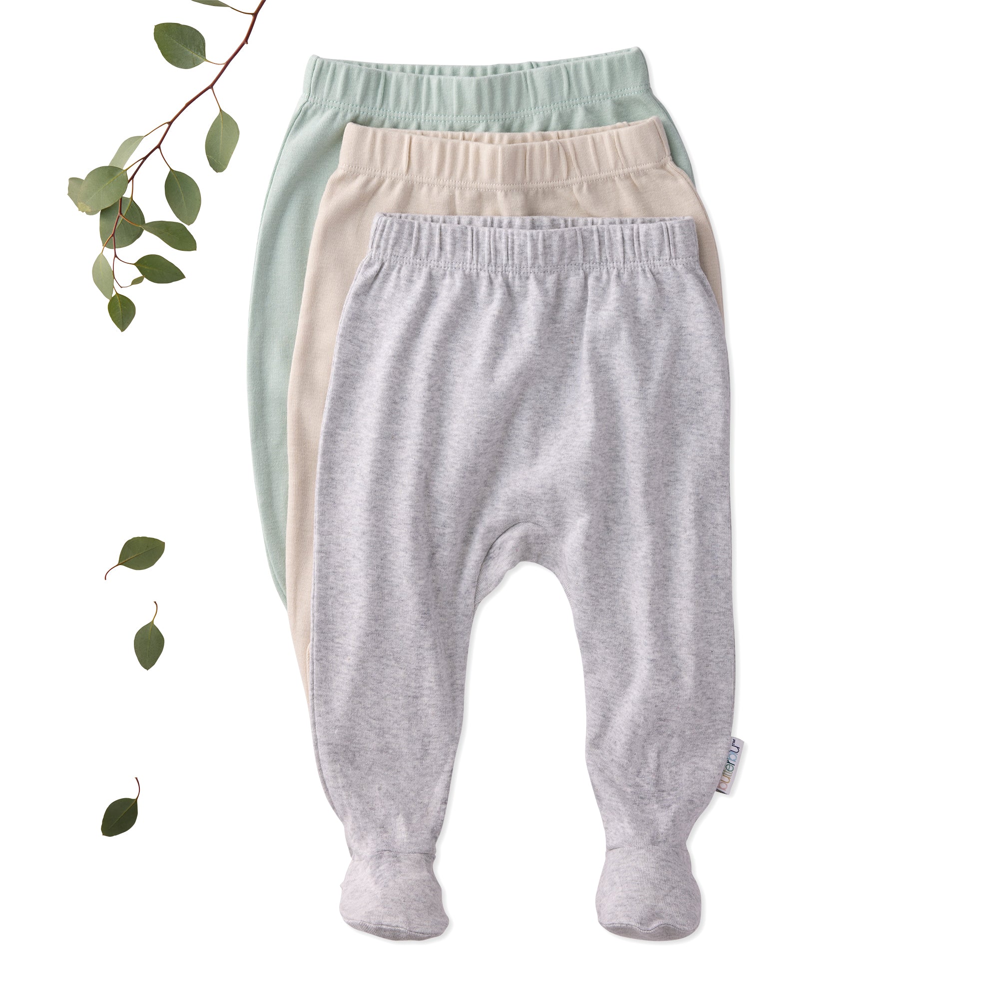 Three pairs of baby pants in green, beige, and gray on a white background with a branch and leaves.