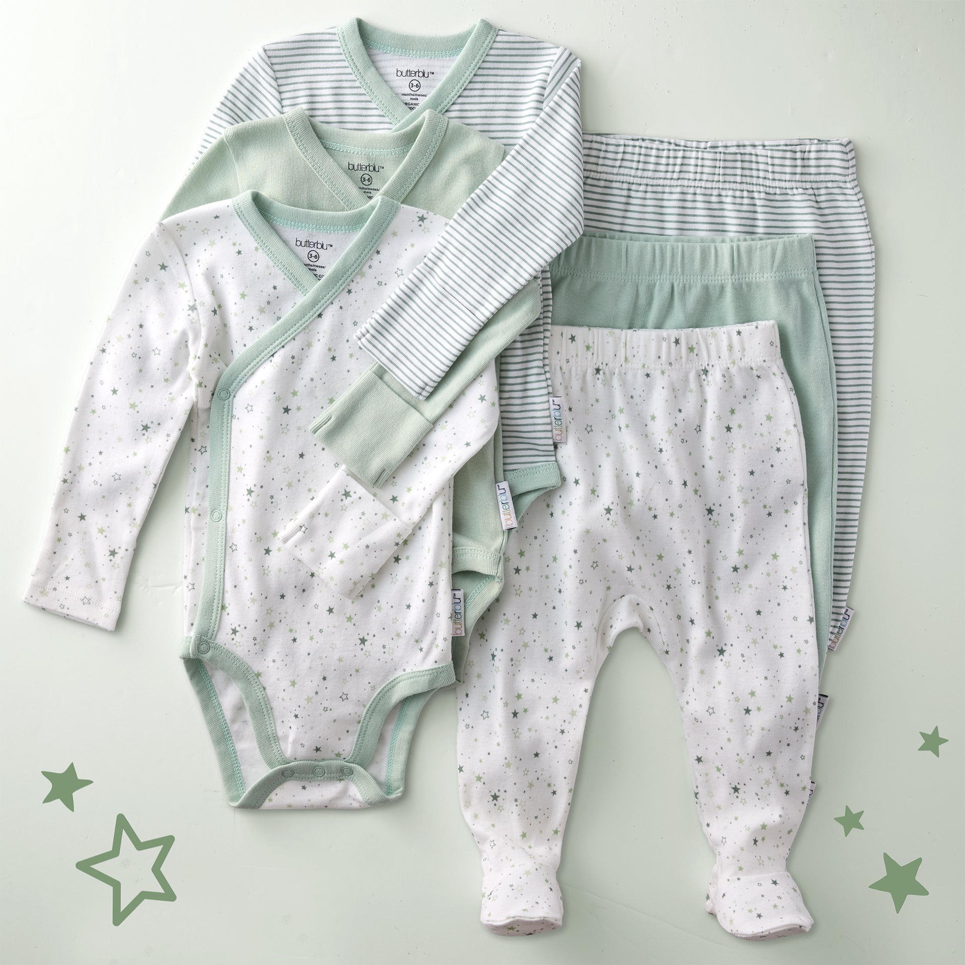 Baby clothing set with onesie and pants on a light green background