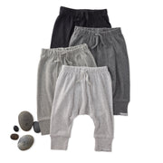 Three pairs of kids pants in black, gray, and white on a white background.