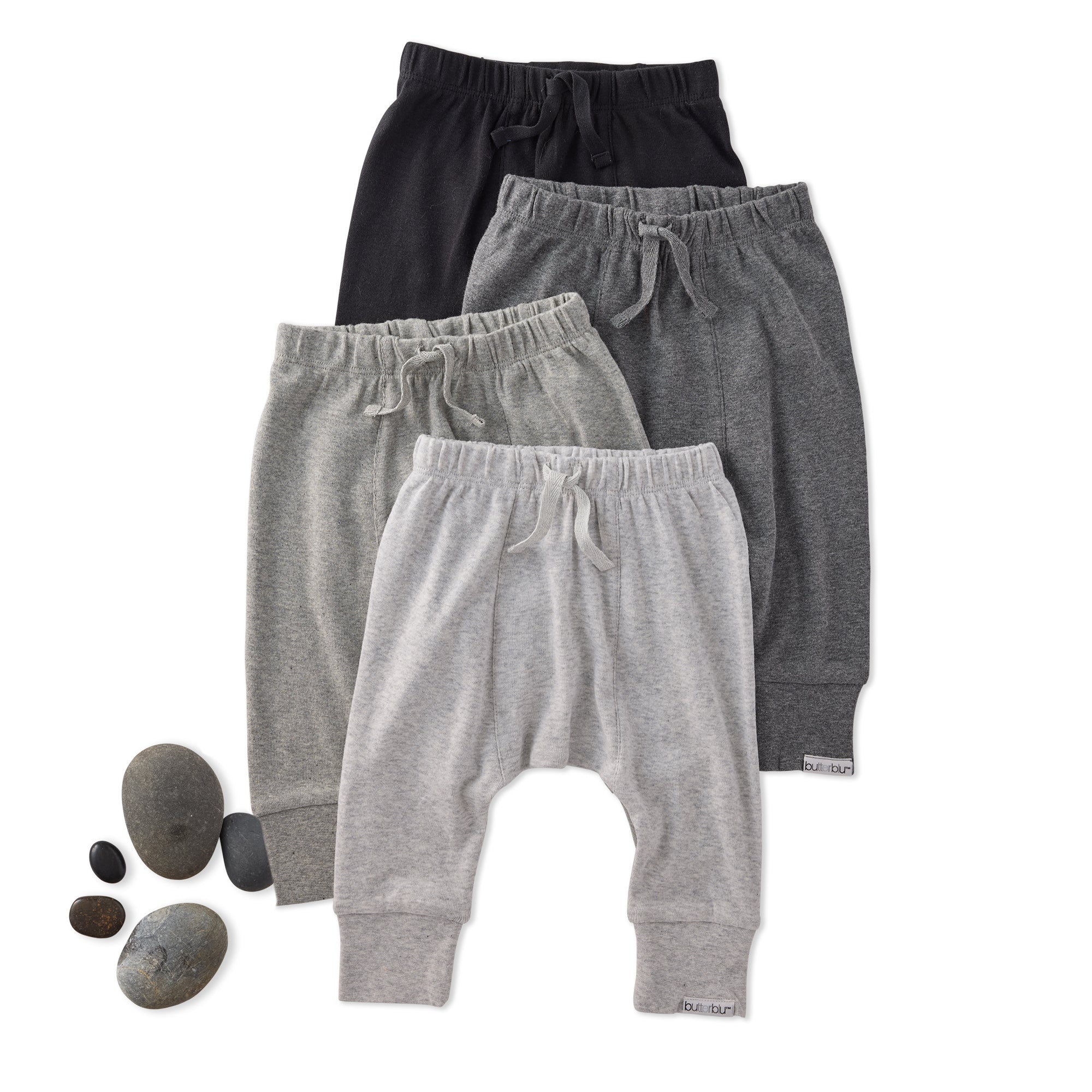 Three pairs of kids pants in black, gray, and white on a white background.