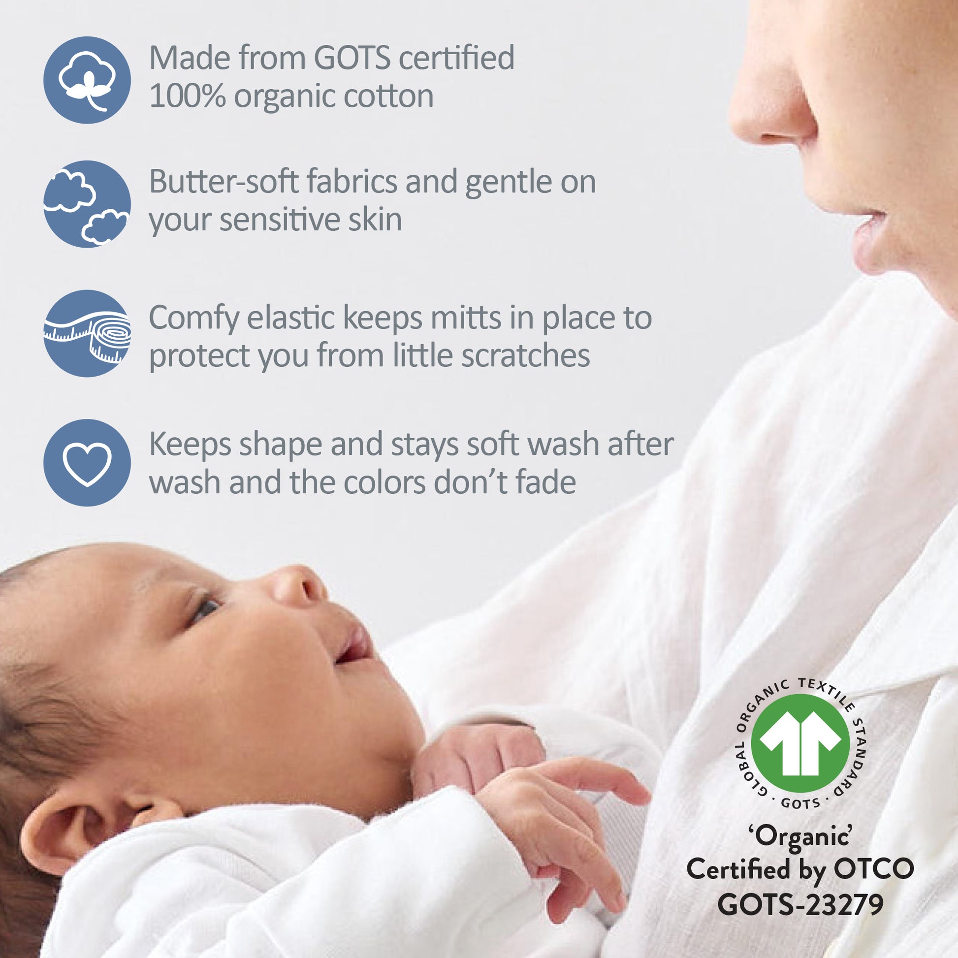Baby wearing white organic cotton clothing with a mother holding them, featuring GOTS certification.