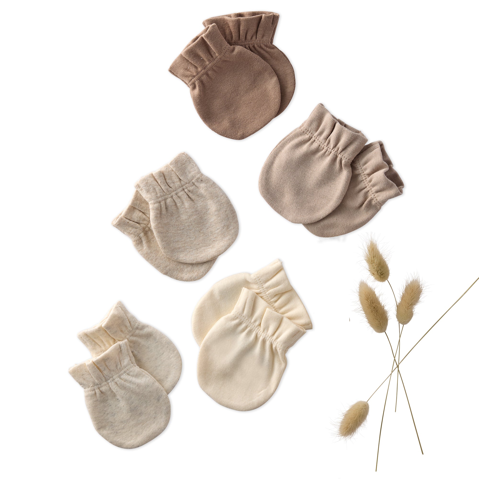 Set of baby mittens in beige and brown on a white background with dried grass.