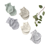 Set of baby mittens in various shades of gray on a white background with green leaves.