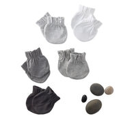 Set of gray and black baby mitts with small stones on a white background