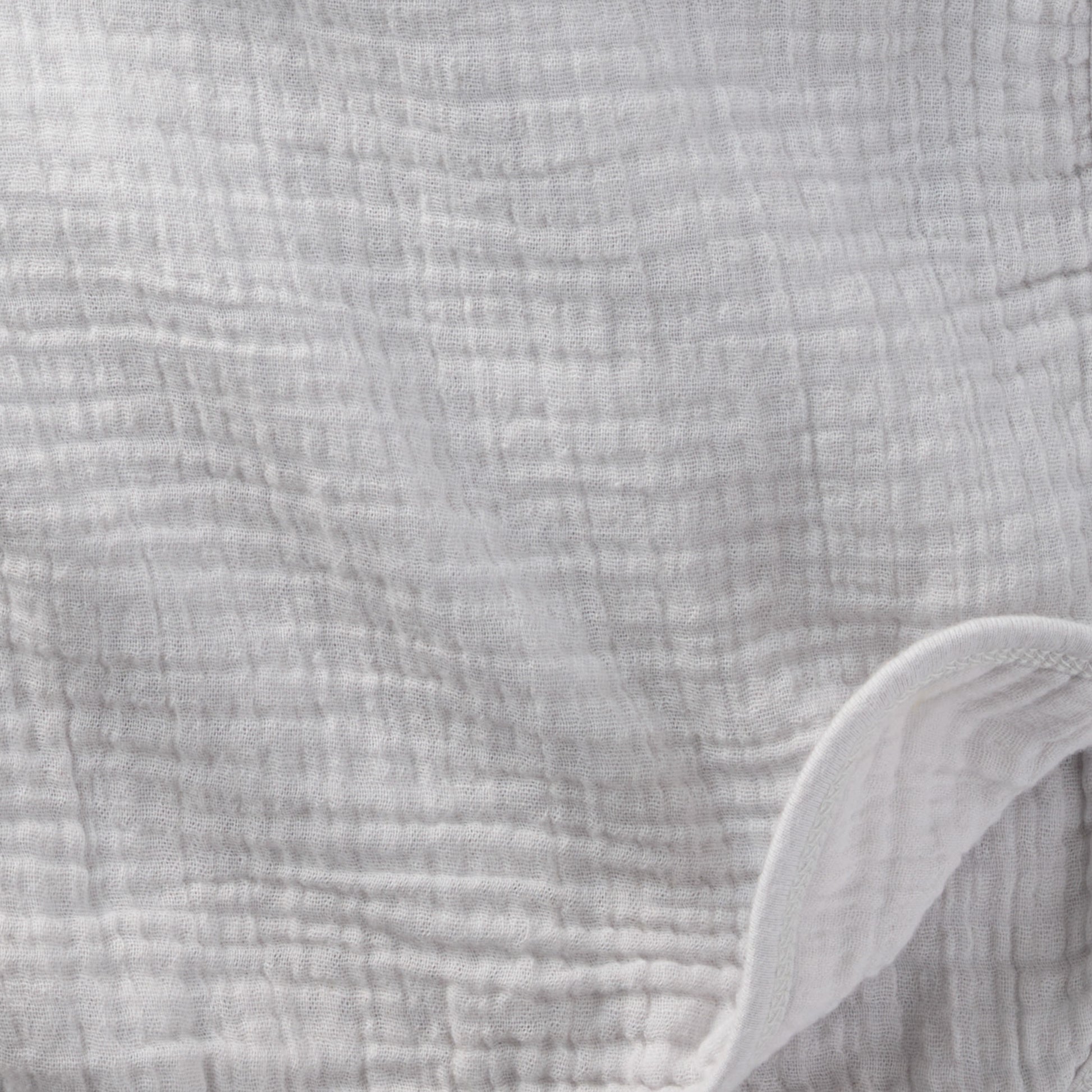 Close-up of textured gray fabric with a white edge