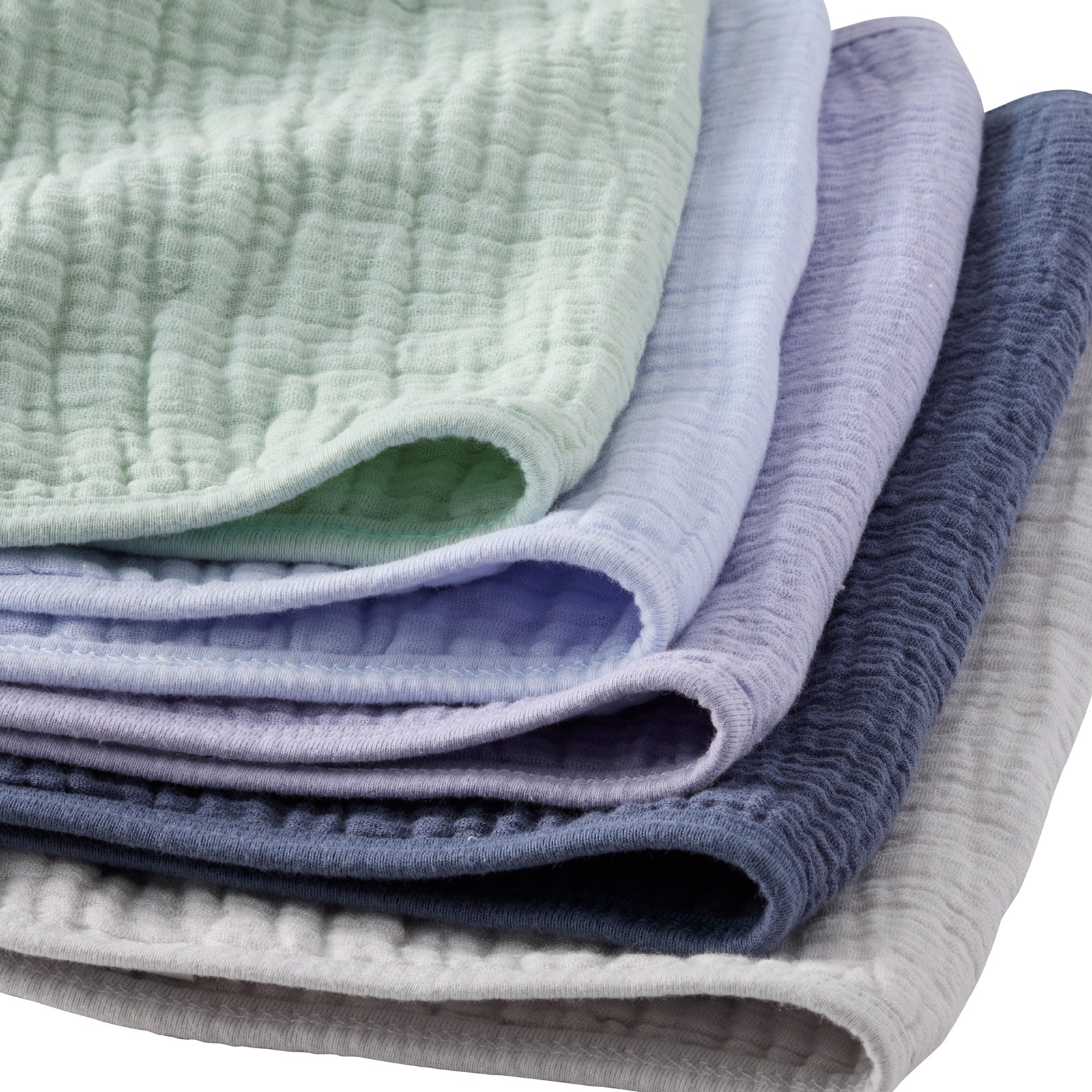 Stack of folded textured fabric sheets in green, purple, and gray on a white background