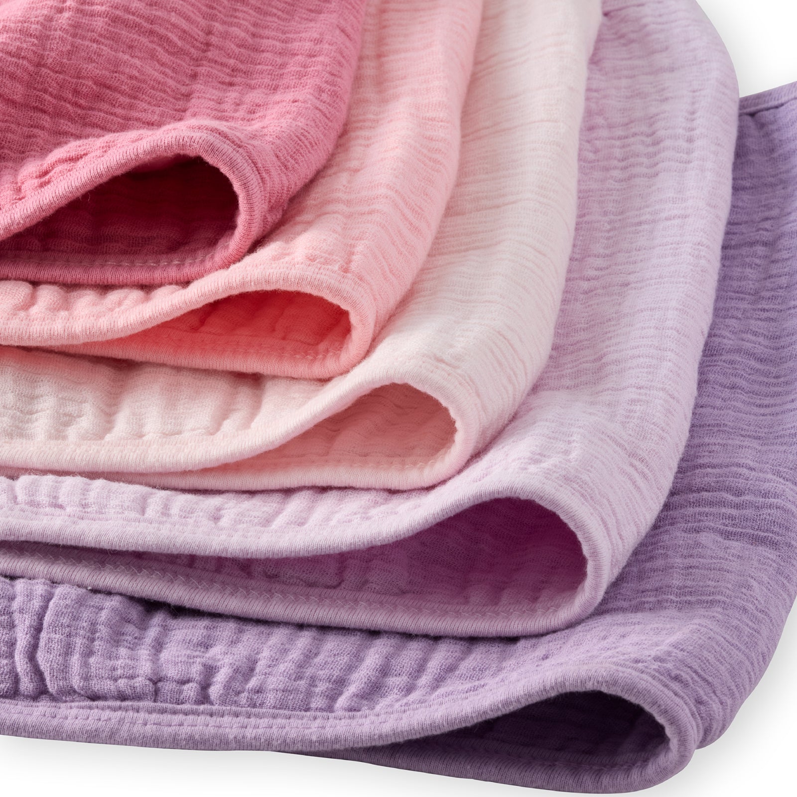 Stack of pink and purple textured fabrics on a white background