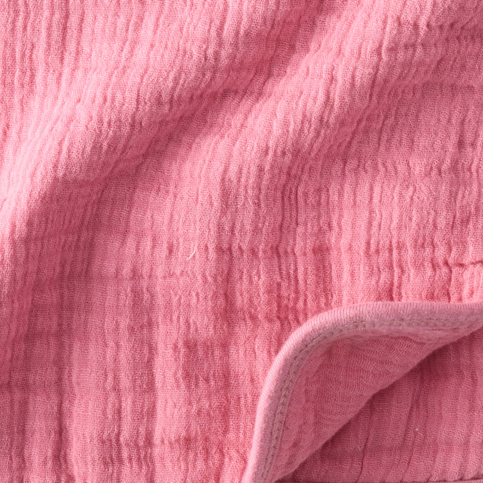 Close-up of pink textured fabric with a folded edge