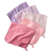 Set of four textured cloths in pink, purple, and white on a white background