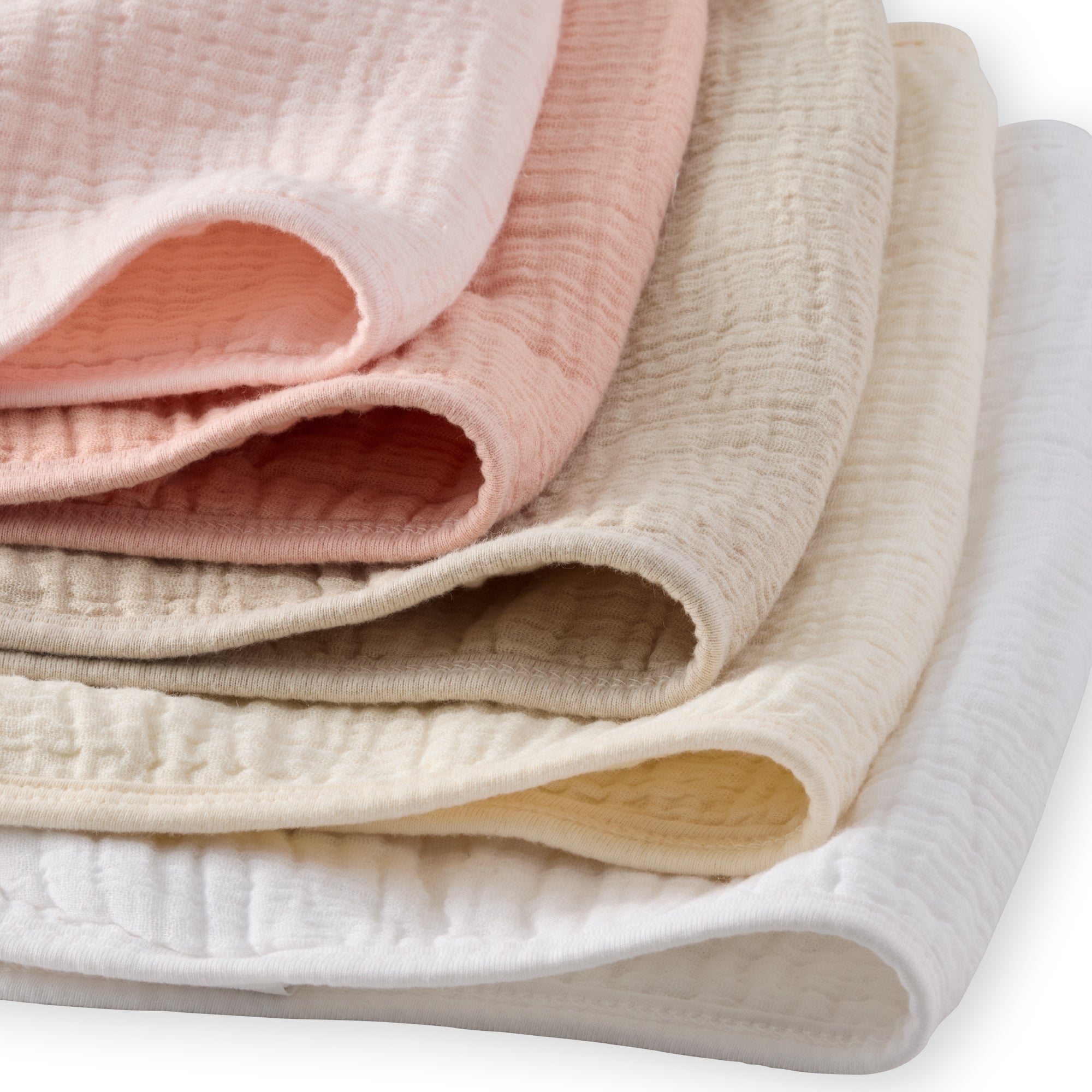 Stack of folded fabric swatches in pink, beige, and white on a white background