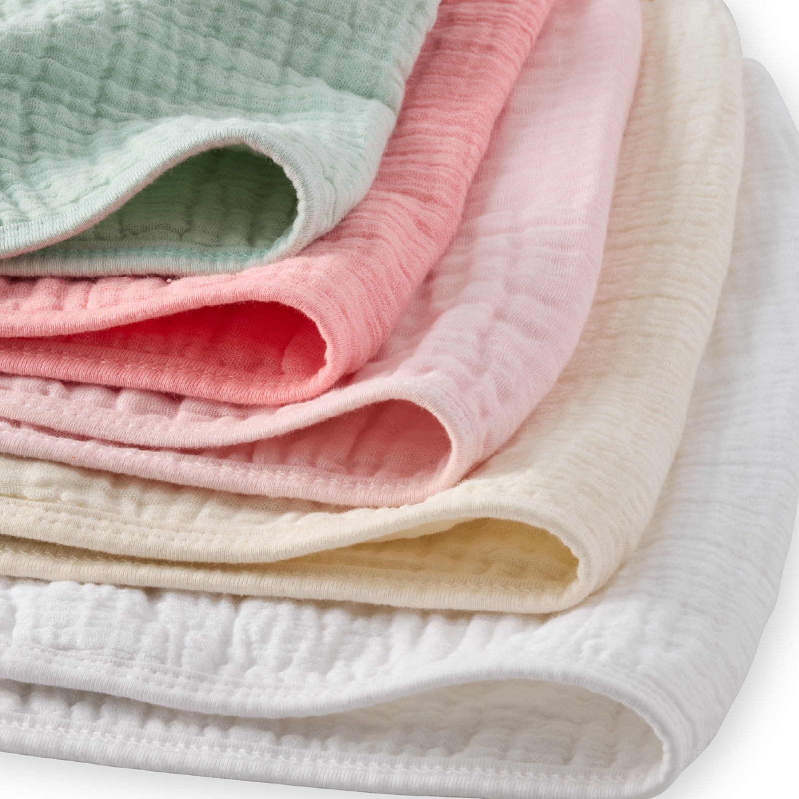 Stack of soft, pastel-colored baby blankets on a white background
