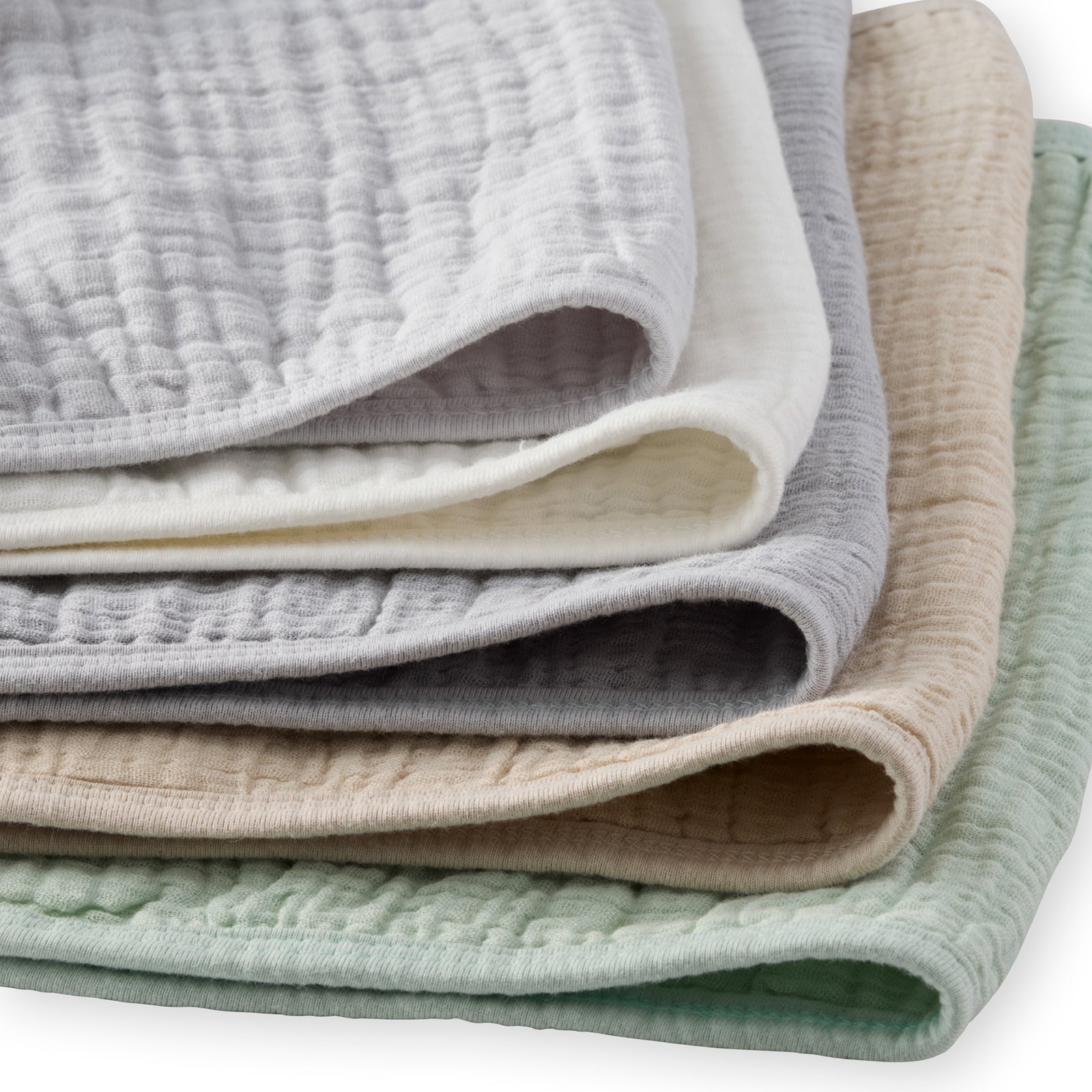 Stack of folded textured fabric swatches in various colors on a white background