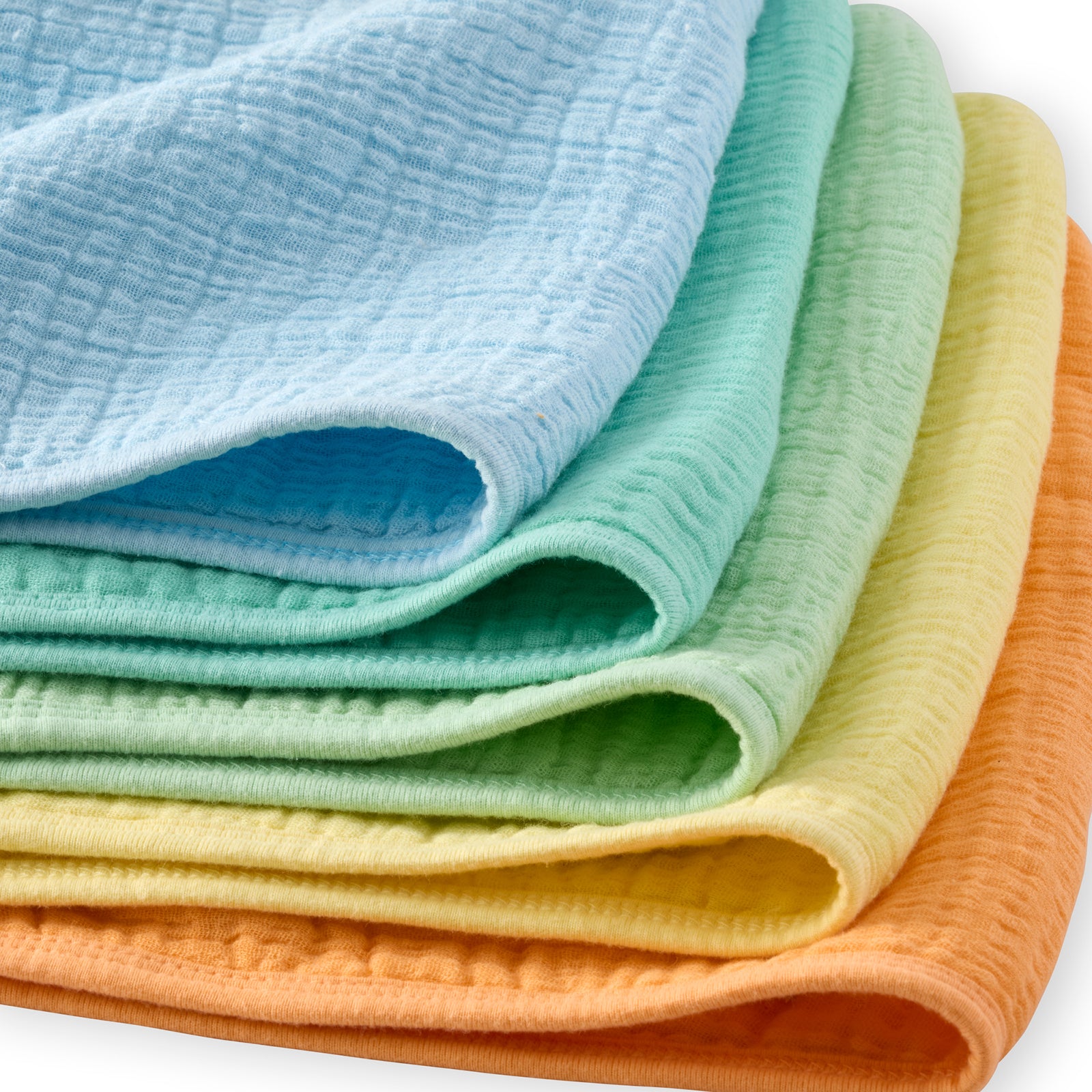 Stack of folded colorful fabrics in blue, green, yellow, and orange on a white background