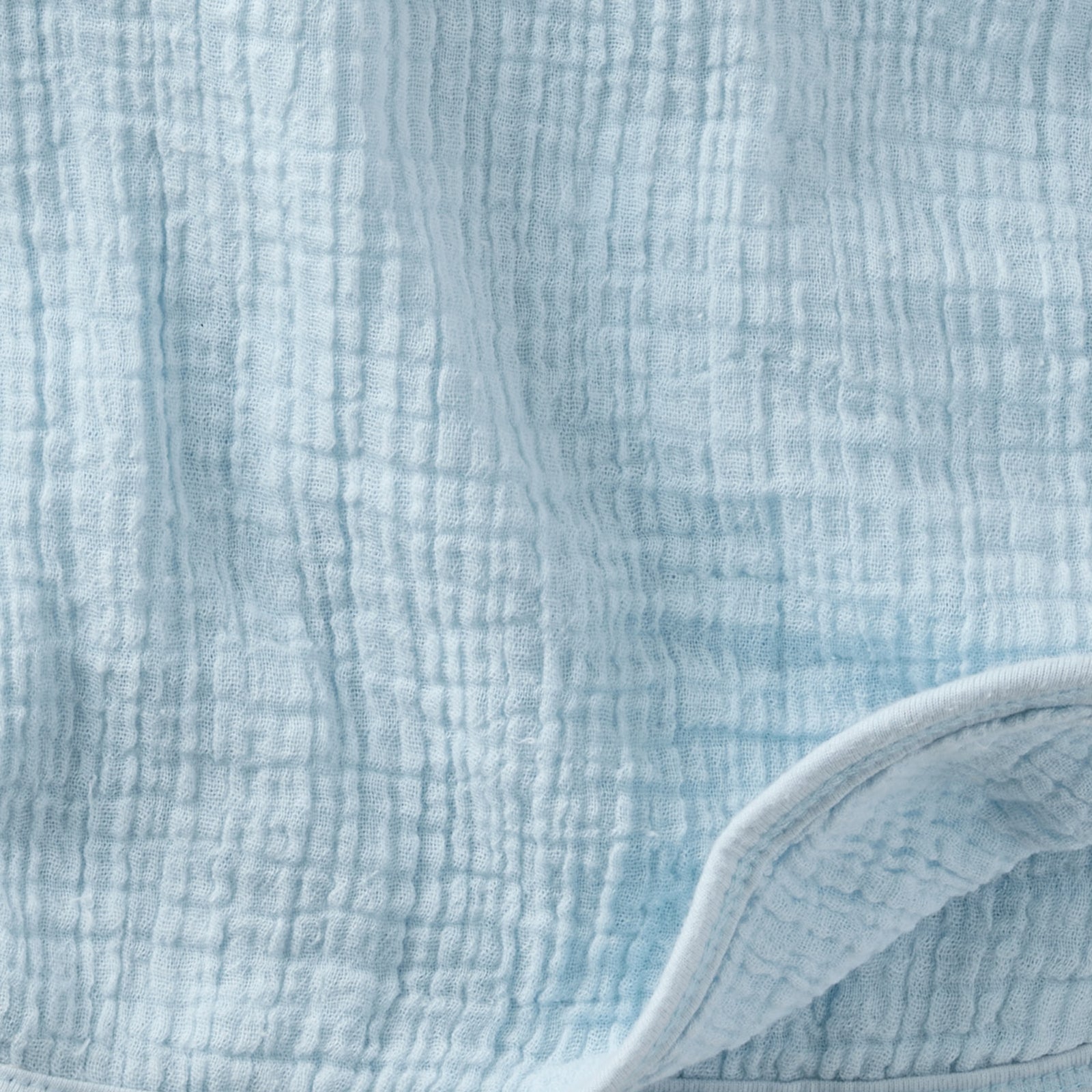 Close-up of textured light blue fabric with a white border